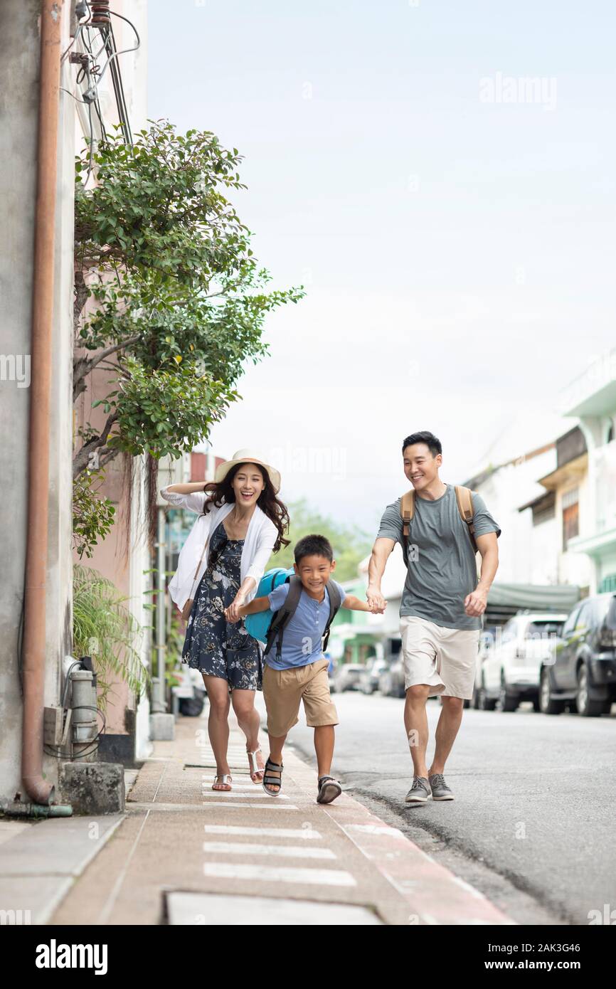 Happy young Chinese family running on street Stock Photo - Alamy