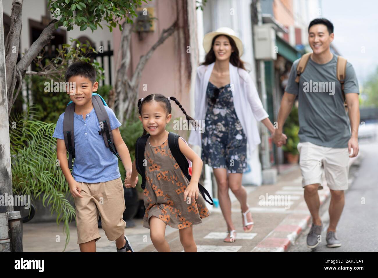 Happy young Chinese family running on street Stock Photo - Alamy