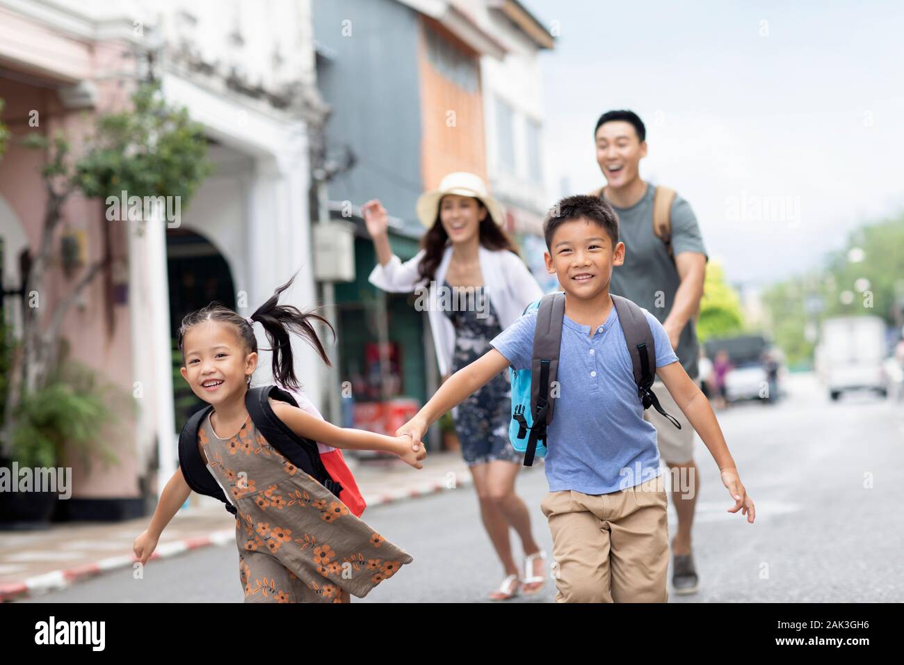 Happy young Chinese family running on street Stock Photo - Alamy