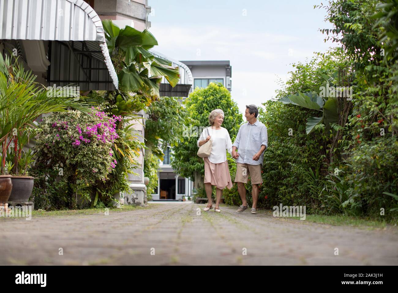 Happy senior Chinese couple holding hands and walking together Stock ...