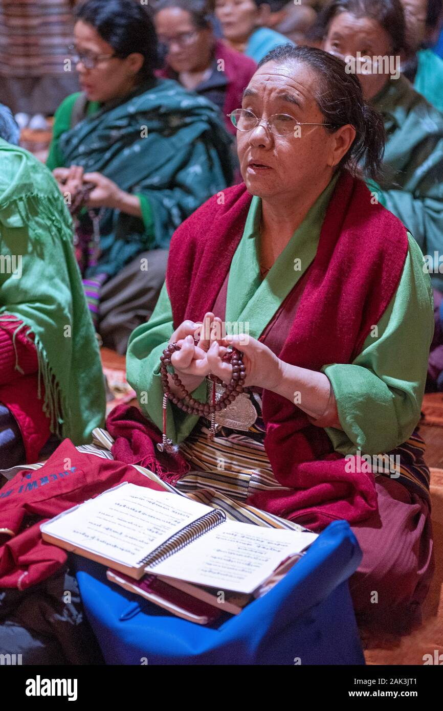 A devout Buddhist worshipper recited prayers while using the correct hand position. At a Tsu Che Puja at a temple in Elmhurst, Queens, New York City. Stock Photo