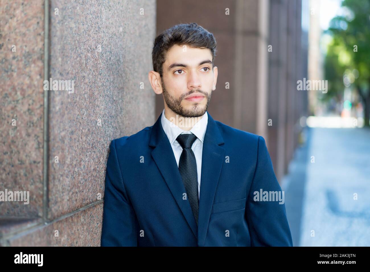 Hipster businessman with beard and suit outdoor in summer in city Stock Photo