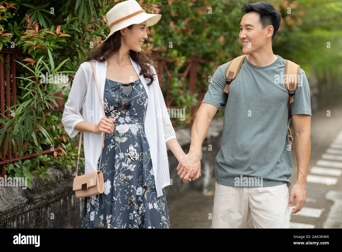 Happy young Chinese couple holding hands on street Stock Photo - Alamy
