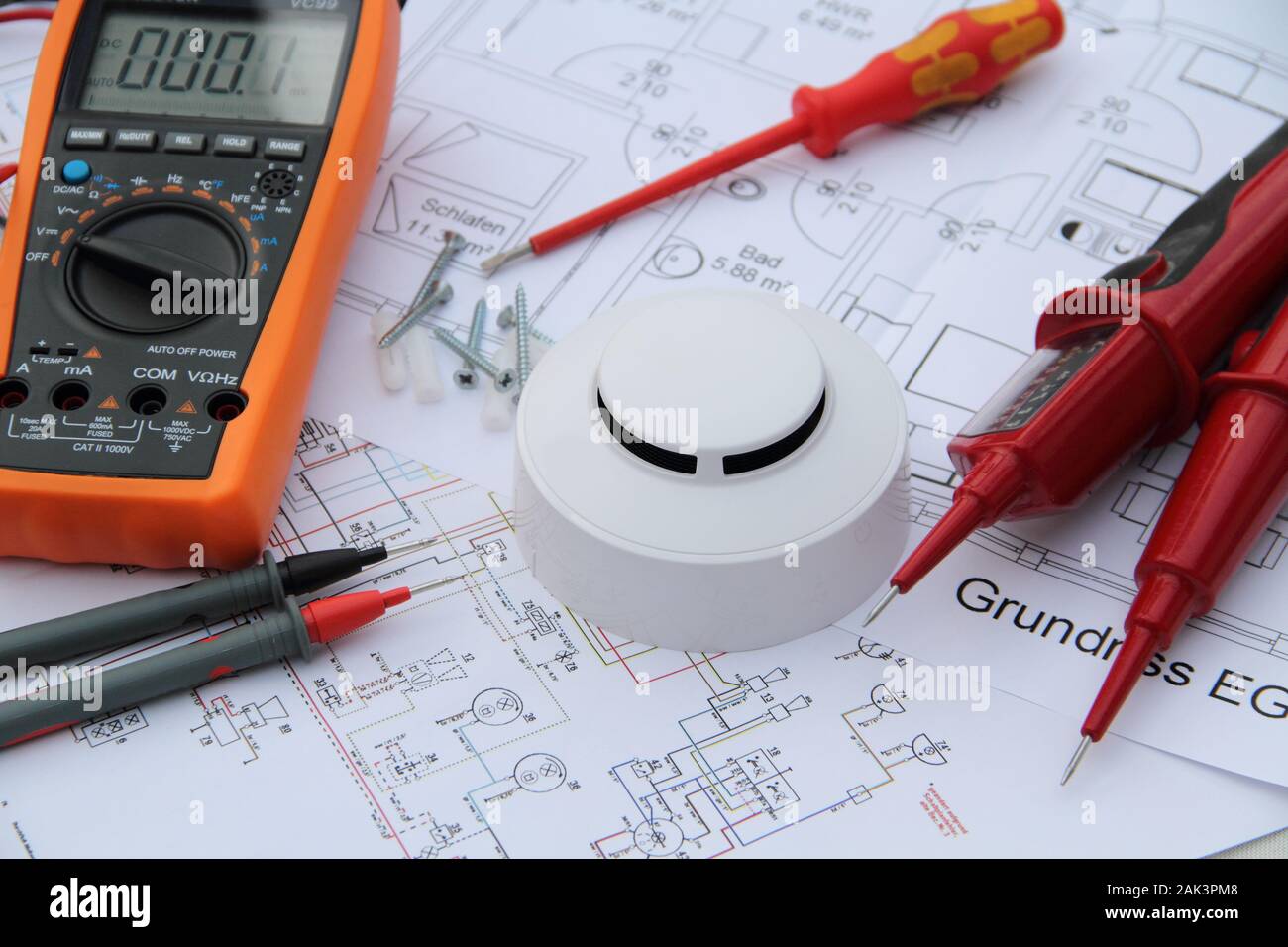 smoke detector with a screwdriver and a measuring device on a circuit diagram Stock Photo