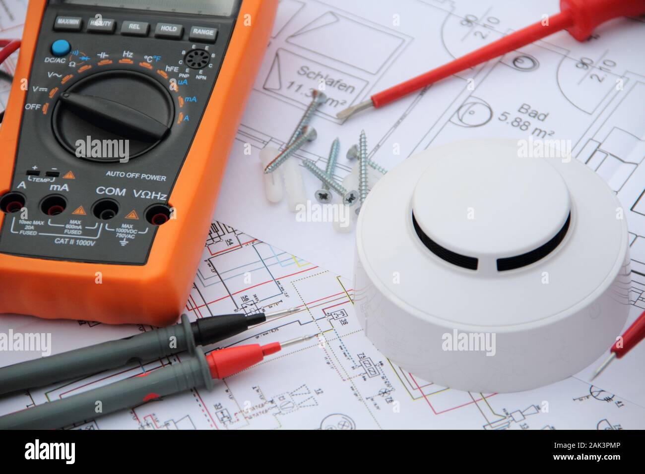 smoke detector with a screwdriver and a measuring device on a circuit