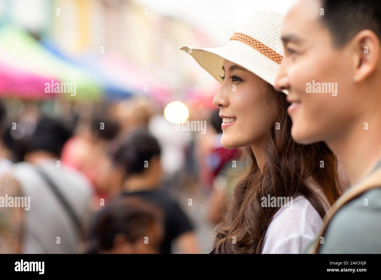 Happy young Chinese couple relaxing in street market Stock Photo - Alamy