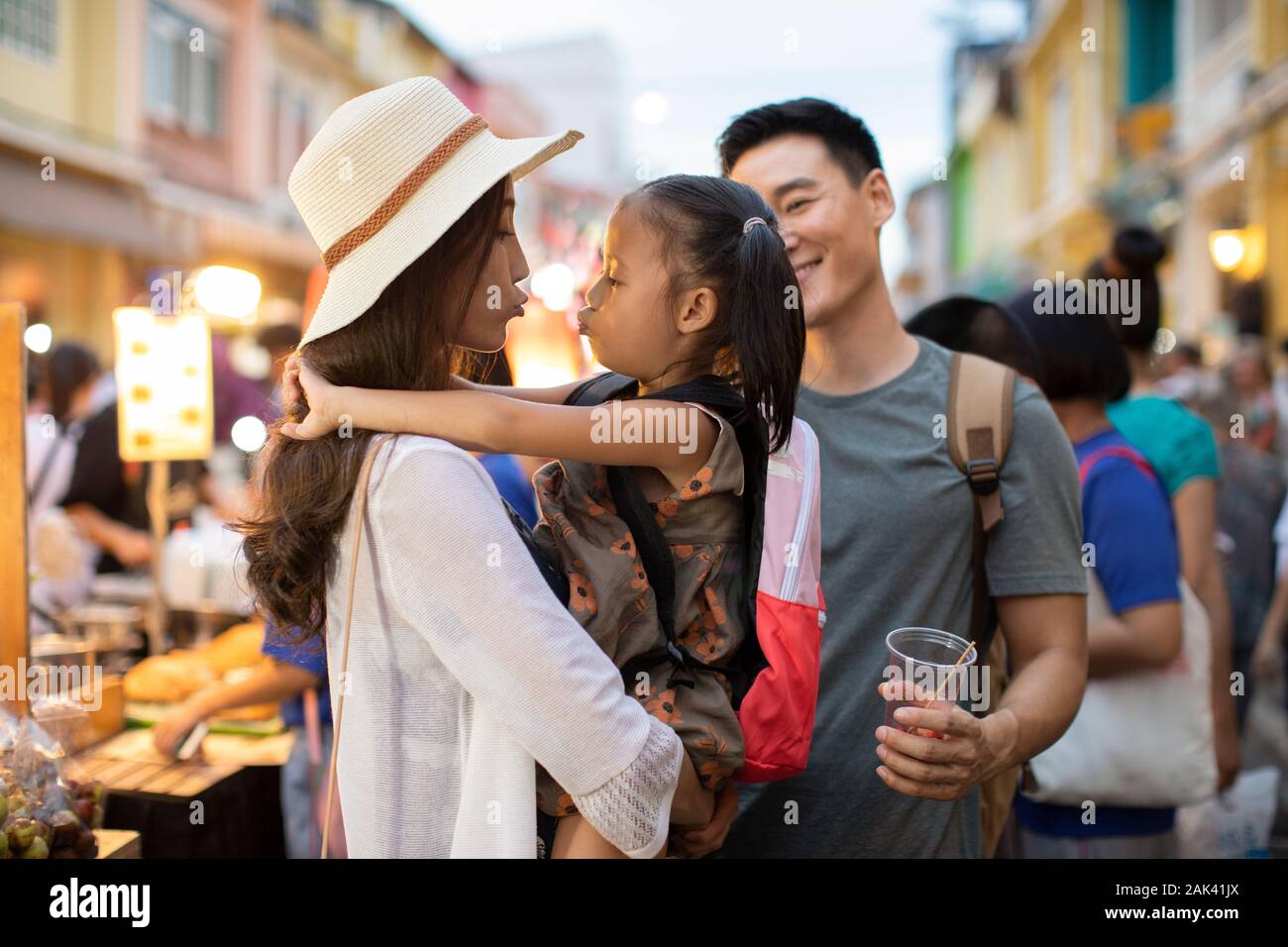 Happy young Chinese family relaxing in street market Stock Photo - Alamy