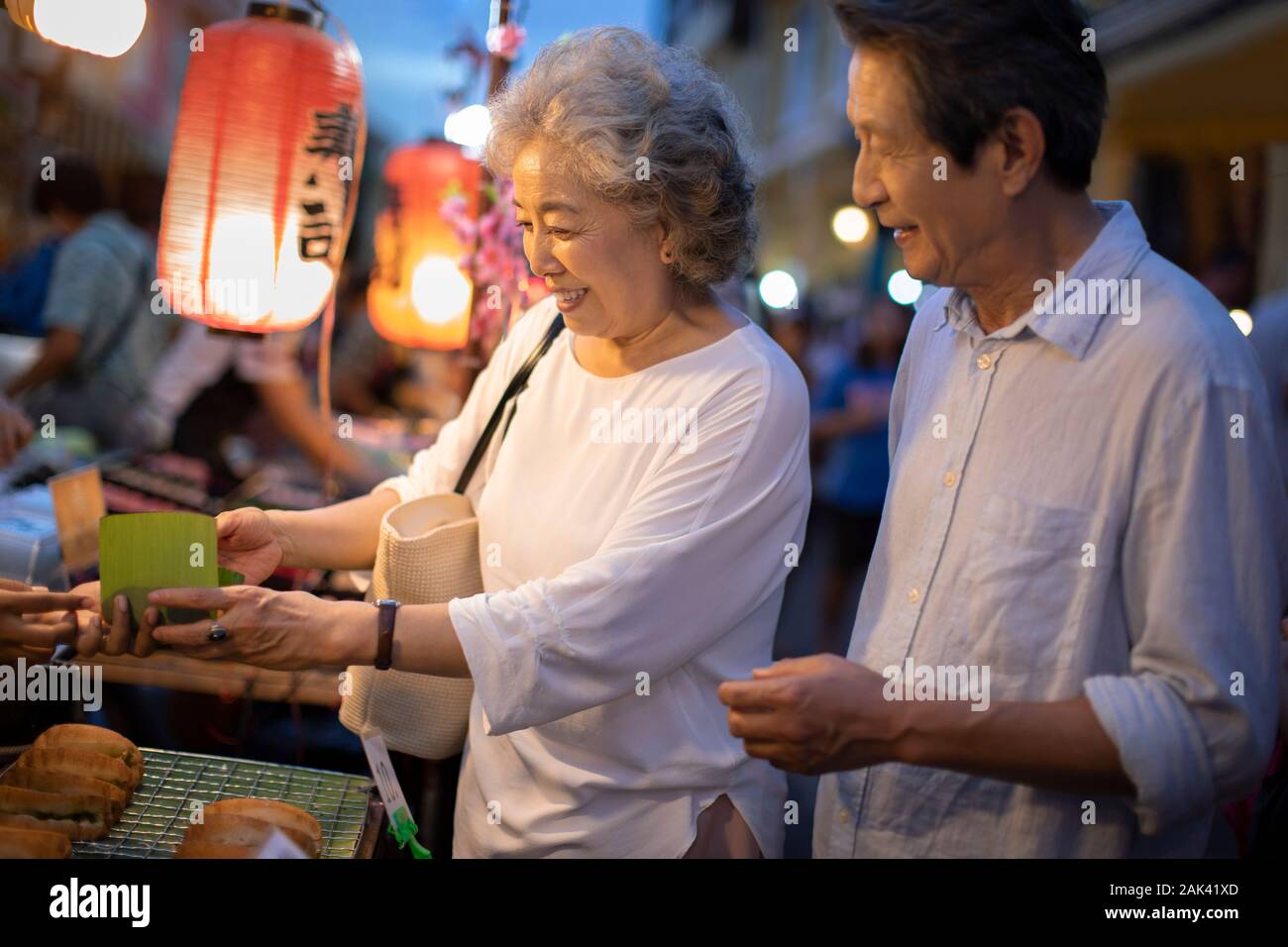 Happy senior Chinese couple relaxing in street market Stock Photo - Alamy