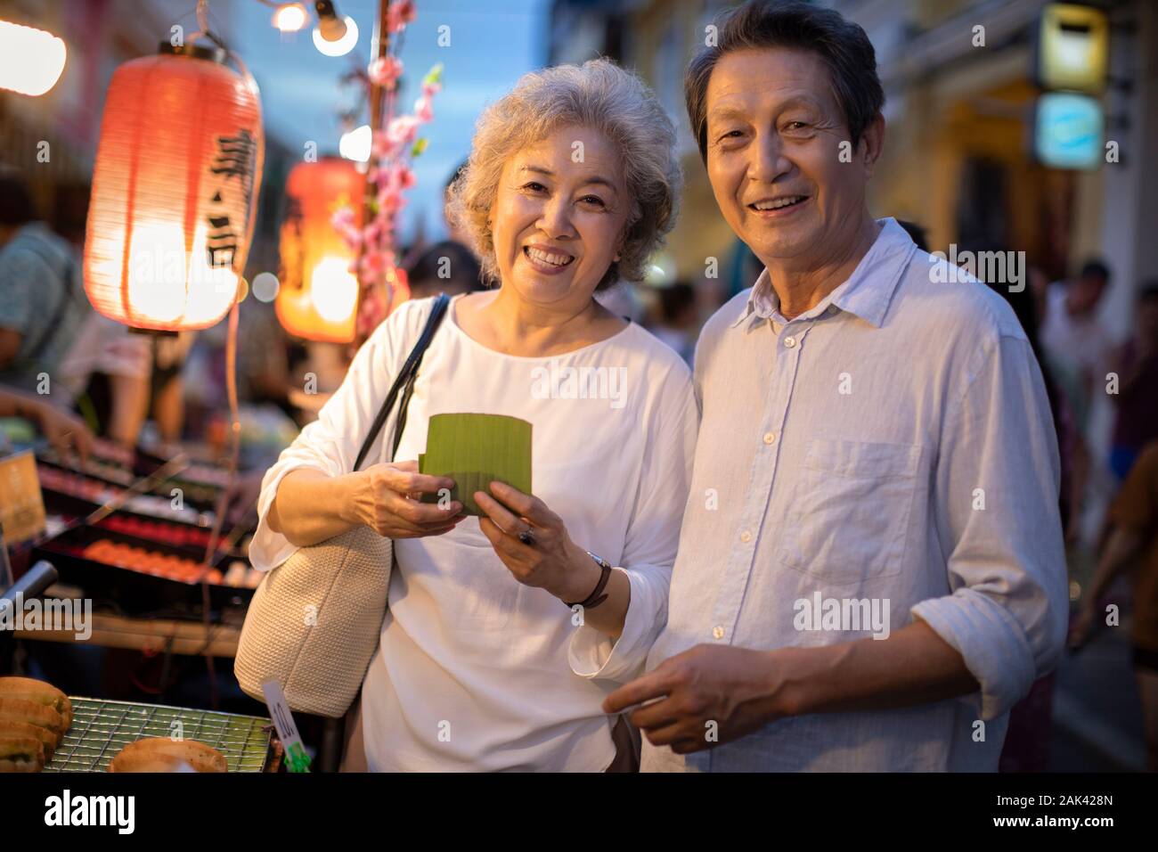 Happy senior Chinese couple relaxing in street market Stock Photo - Alamy