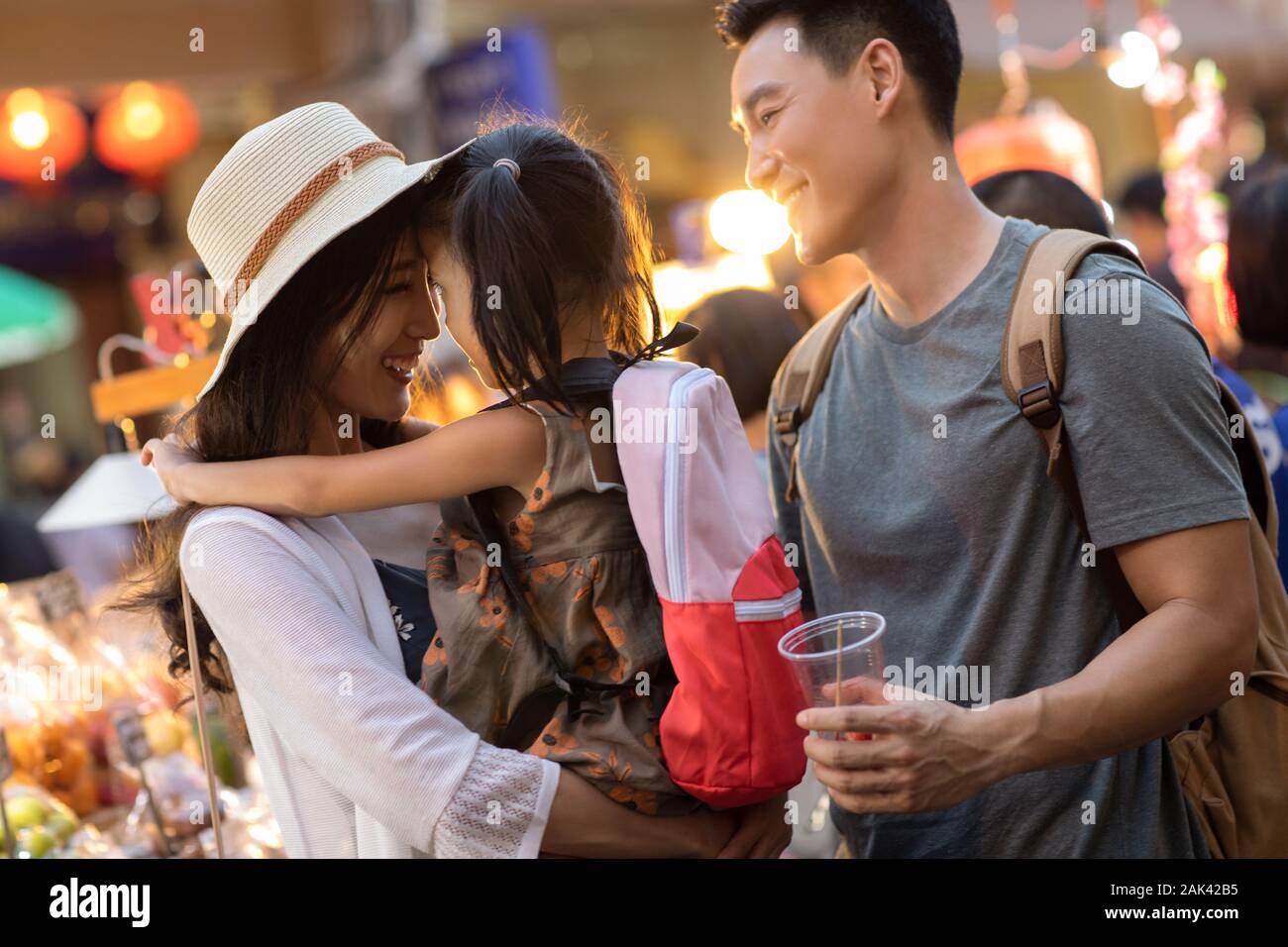 Happy young Chinese family relaxing in street market Stock Photo - Alamy