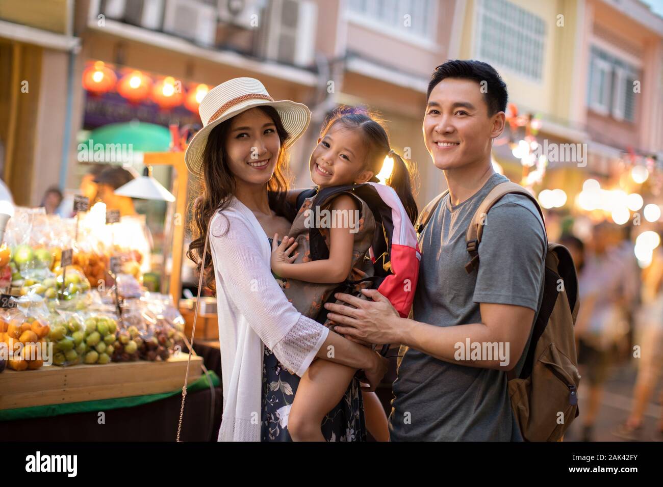 Happy young Chinese family relaxing in street market Stock Photo - Alamy