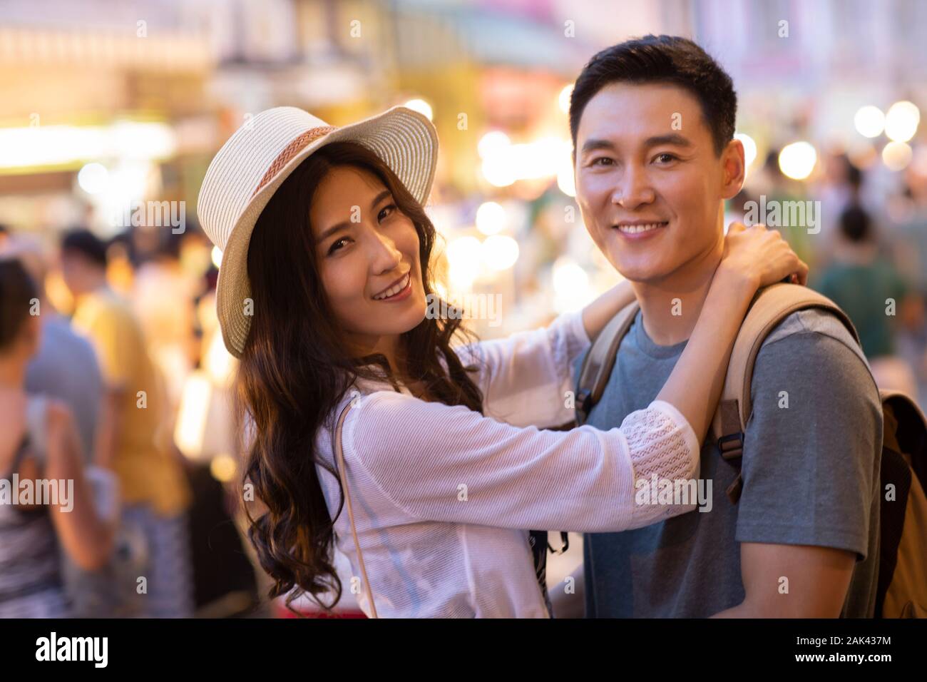 Happy young Chinese couple relaxing in street market Stock Photo - Alamy