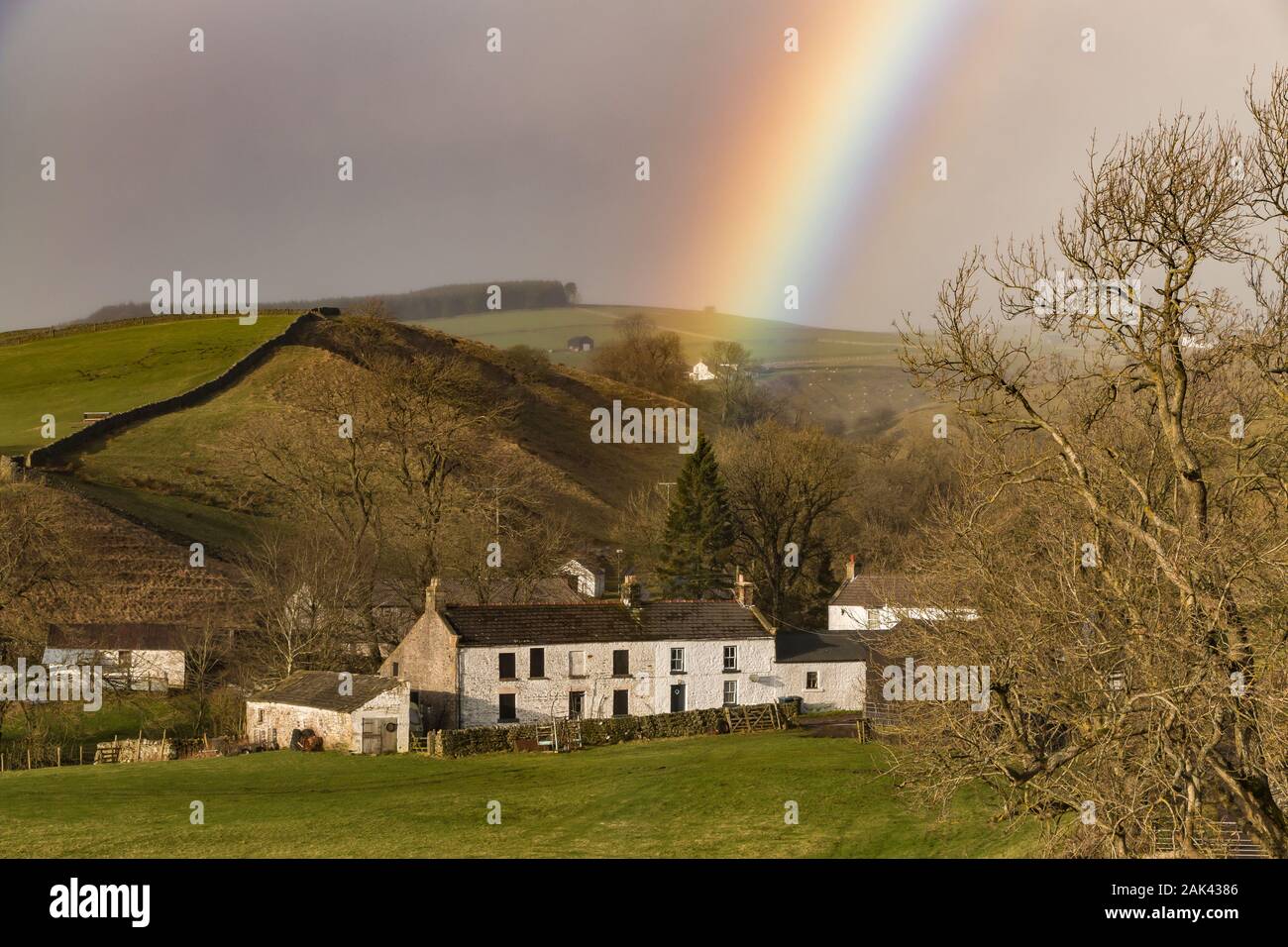 The end of a vivid rainbow drops onto the wonderfully named 'Dirt Pit' farm, Ettersgill, Upper Teesdale, within the North Pennines AONB Stock Photo