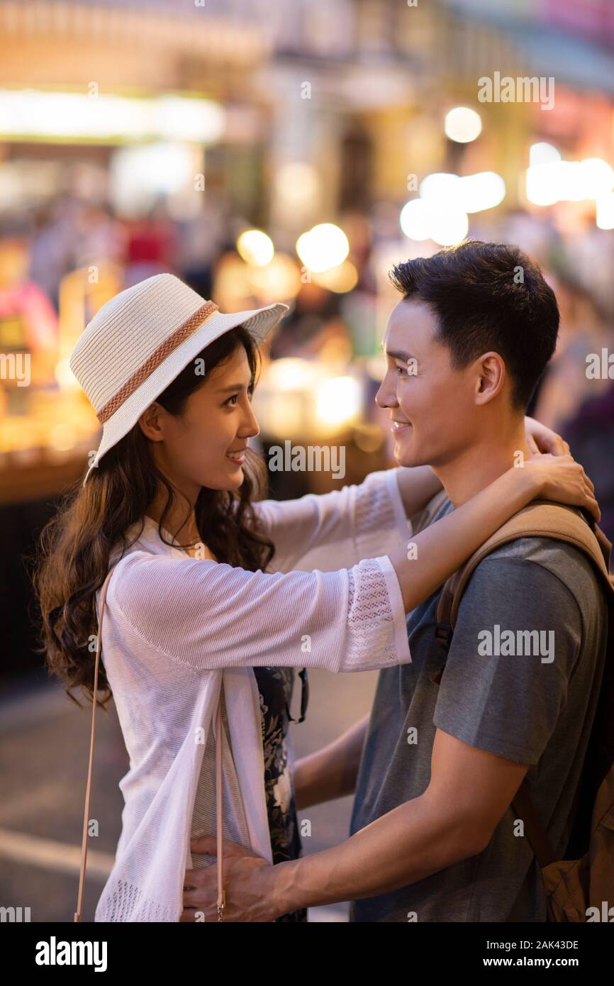 Happy young Chinese couple relaxing in street market Stock Photo - Alamy