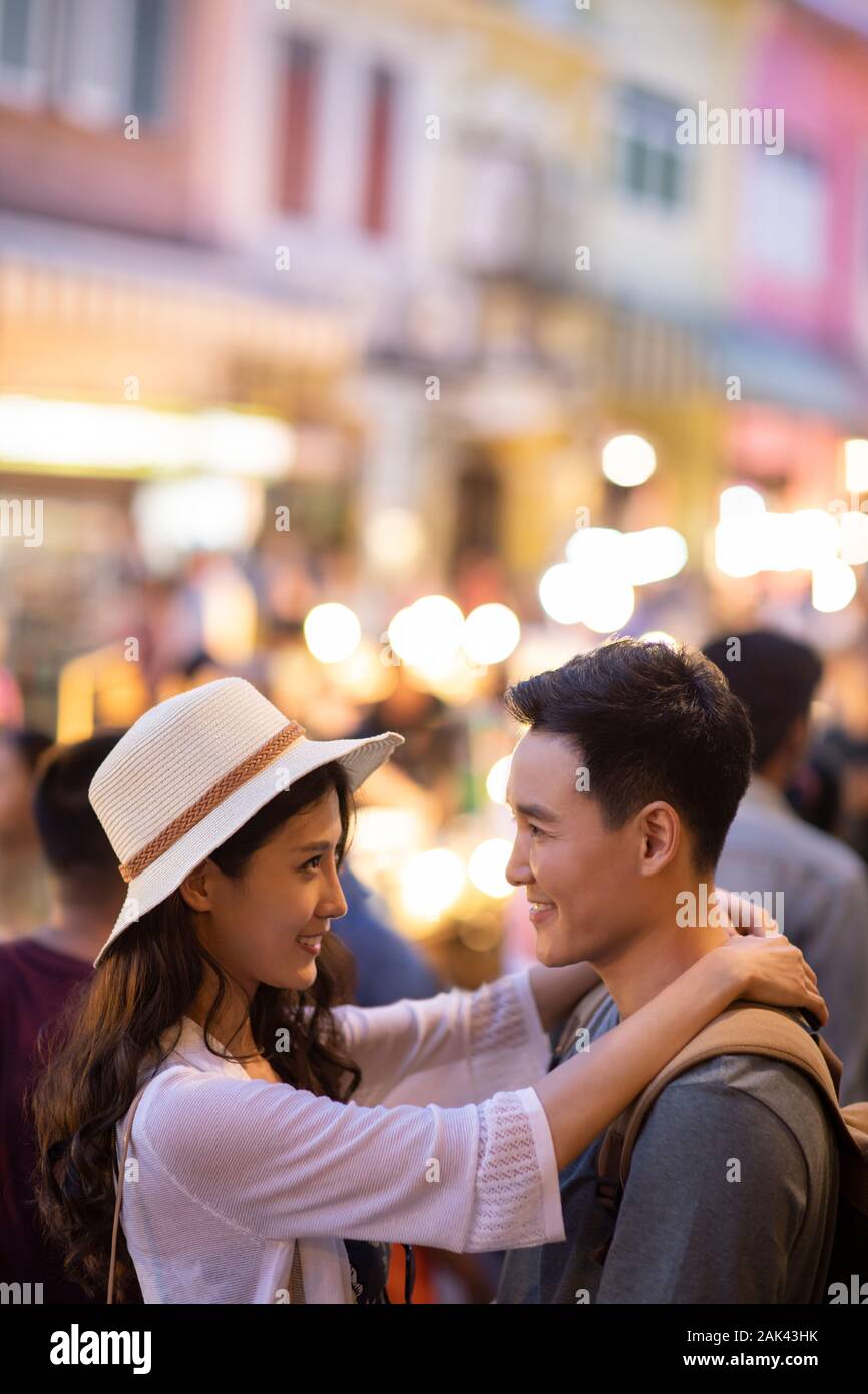 Happy young Chinese couple relaxing in street market Stock Photo - Alamy