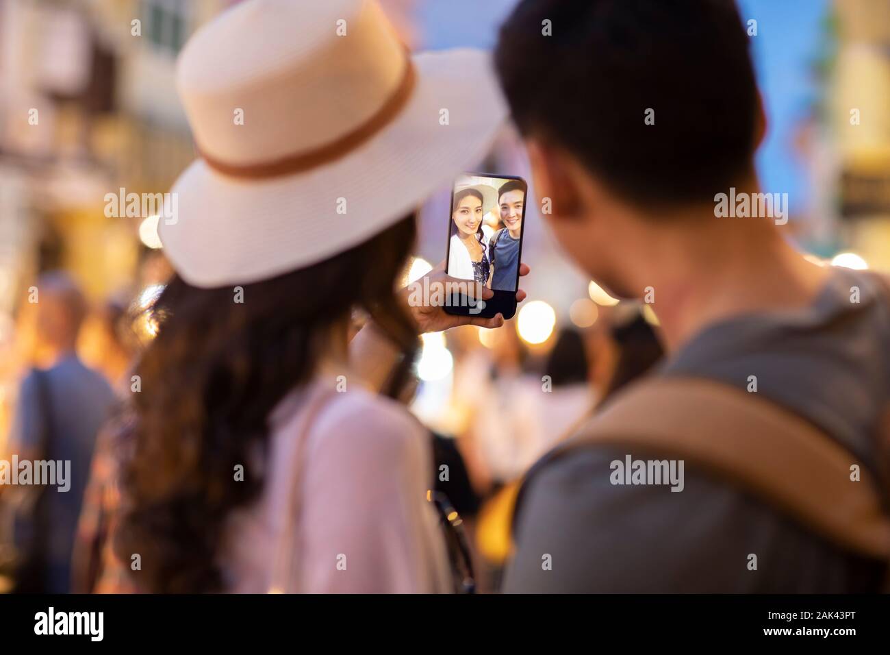 Happy young Chinese couple taking selfie in street market Stock Photo ...