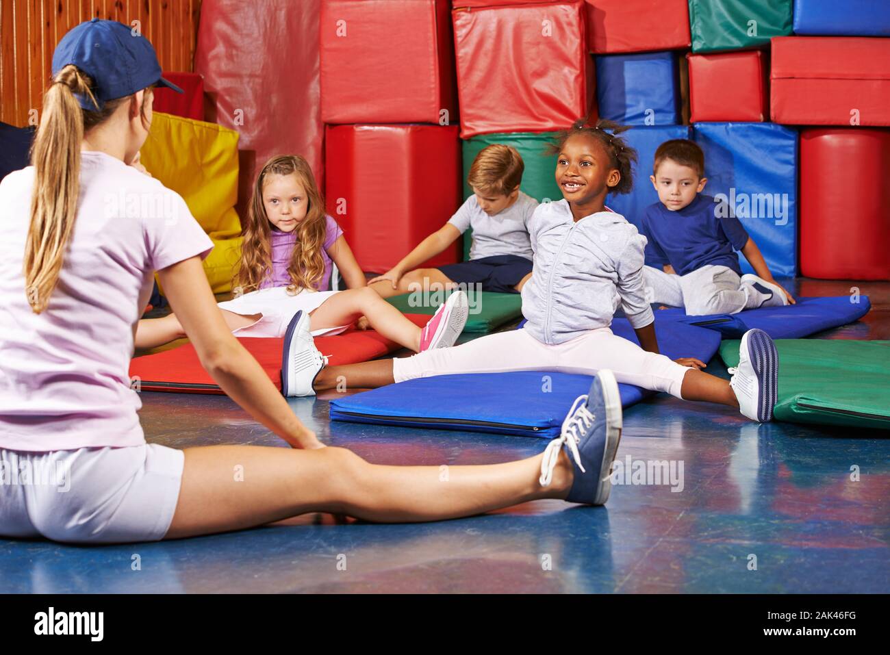 Children do gymnastics at the Kindergarden in kindergarten together with the kindergarten teacher Stock Photo