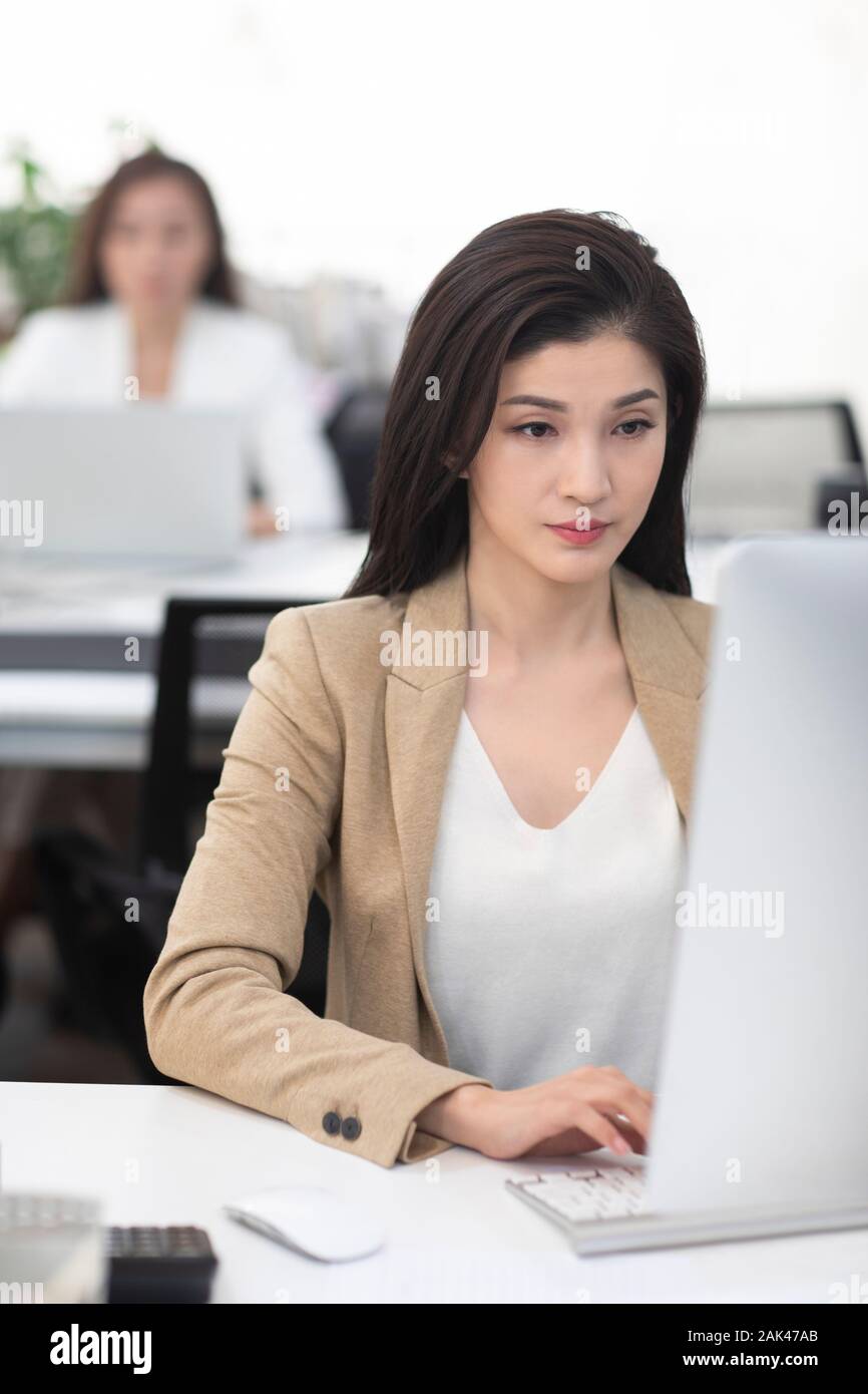 Chinese businesswomen using computer in office Stock Photo