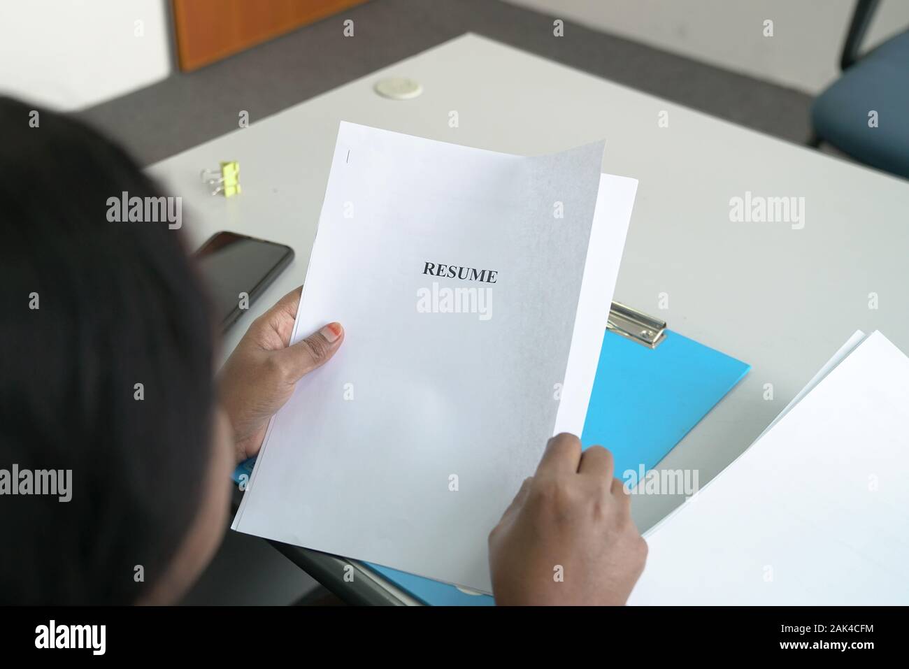 Hiring Manager holding a copy of resume in her hands in the office Stock Photo