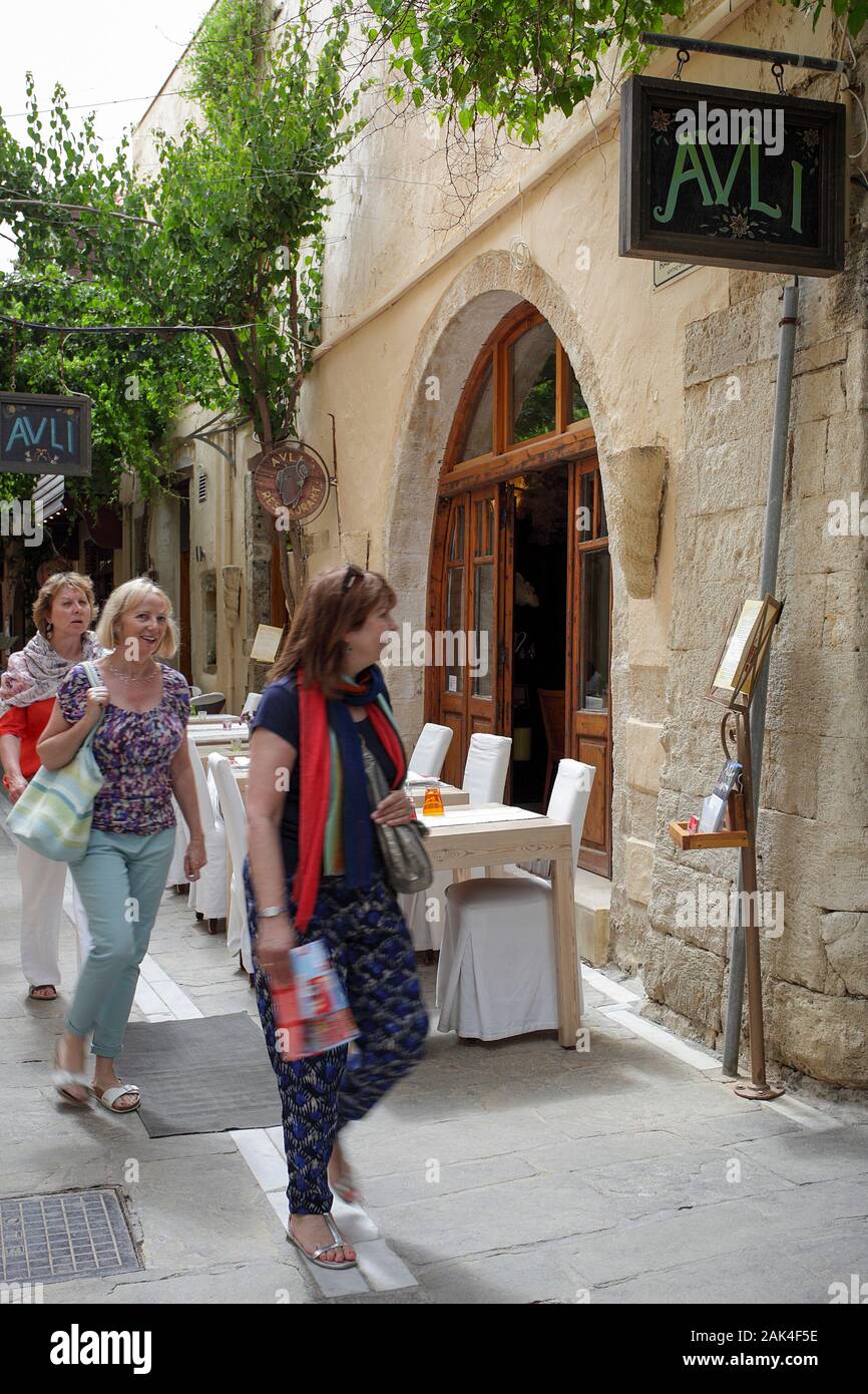 Three female holidaymakers walking past the Avli Restaurant in the old ...
