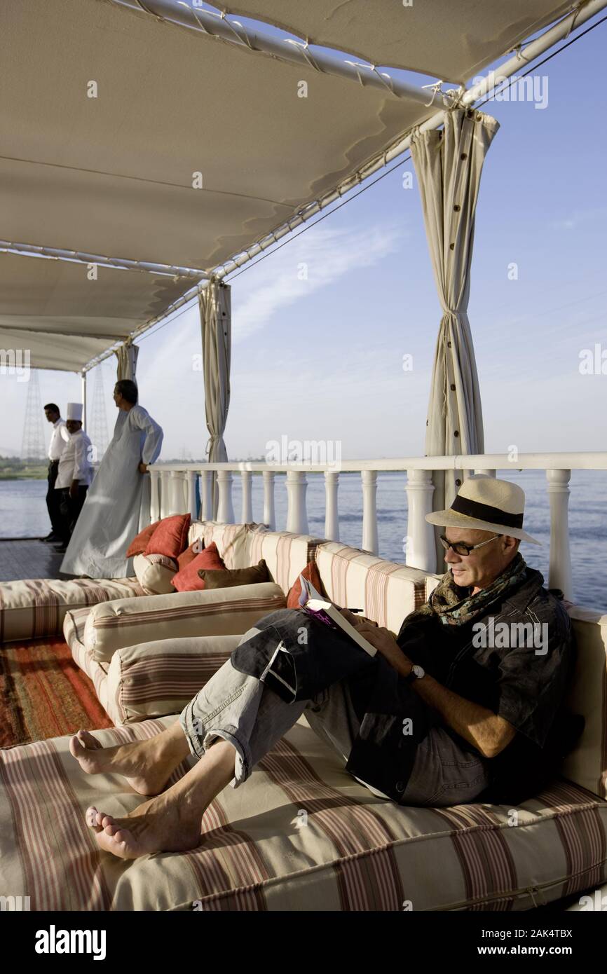 Luxor: Lektüre auf einem Segelboot auf dem Nil, Ägypten | usage worldwide Stock Photo