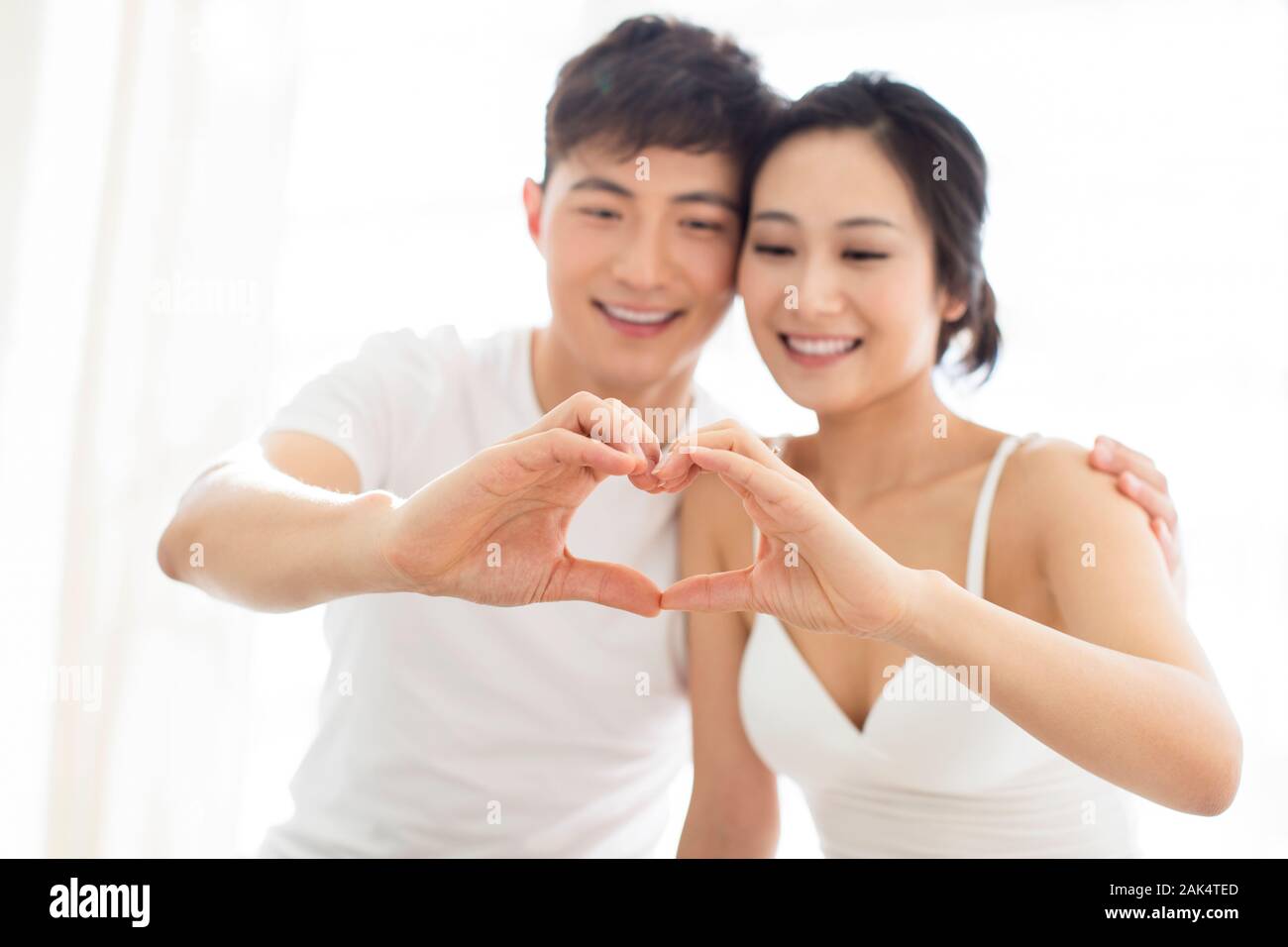 Happy young Chinese couple making heart shape Stock Photo - Alamy