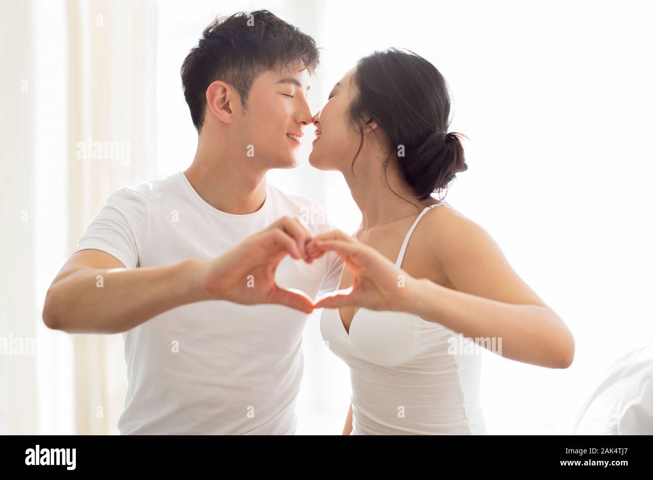 Happy young Chinese couple making heart shape Stock Photo - Alamy