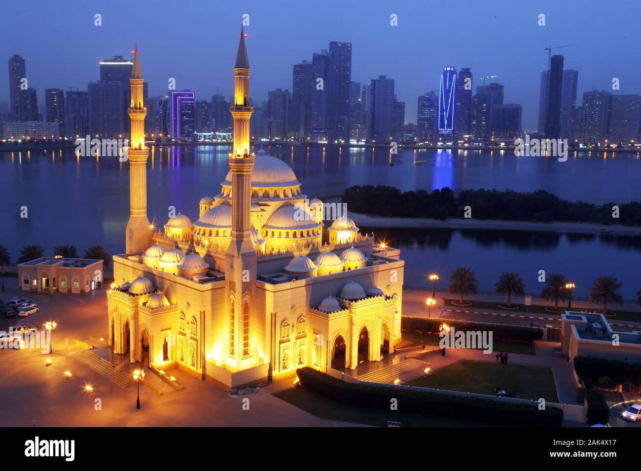 Sharjah: Al Noor Mosque Moschee an der Buhaira Corniche mit Blick ueber die Khalid Lagoon auf die naechtliche Skyline von Sharjah, Dubai | usage world Stock Photo