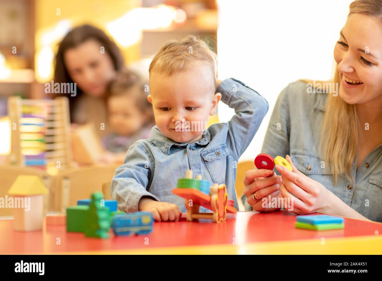 Children kids play with educational toys, arranging and sorting colors and shapes. Learning through experience conception. Stock Photo