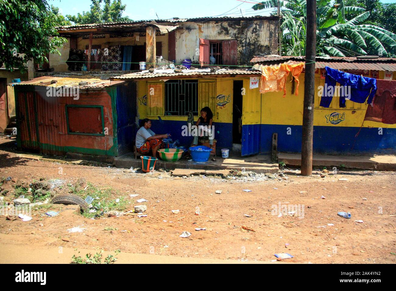 Two women sitting and talking on the patio in front of their house in