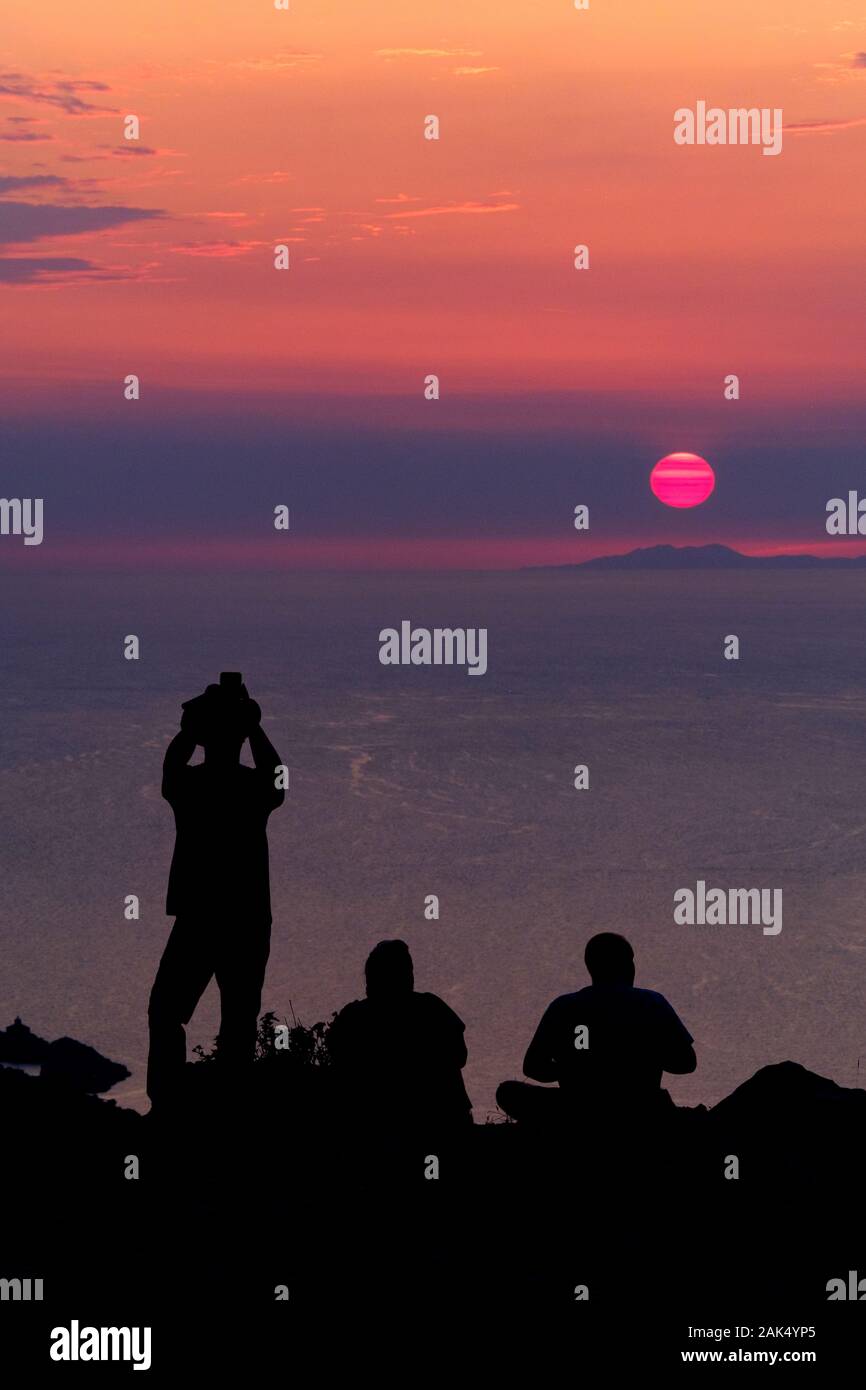 A tourist takes a picture of a beautiful sunset out of the Adriatic sea. The tourists are at the top of Mount Srd, above Dubrovnik, Southern Croatia Stock Photo