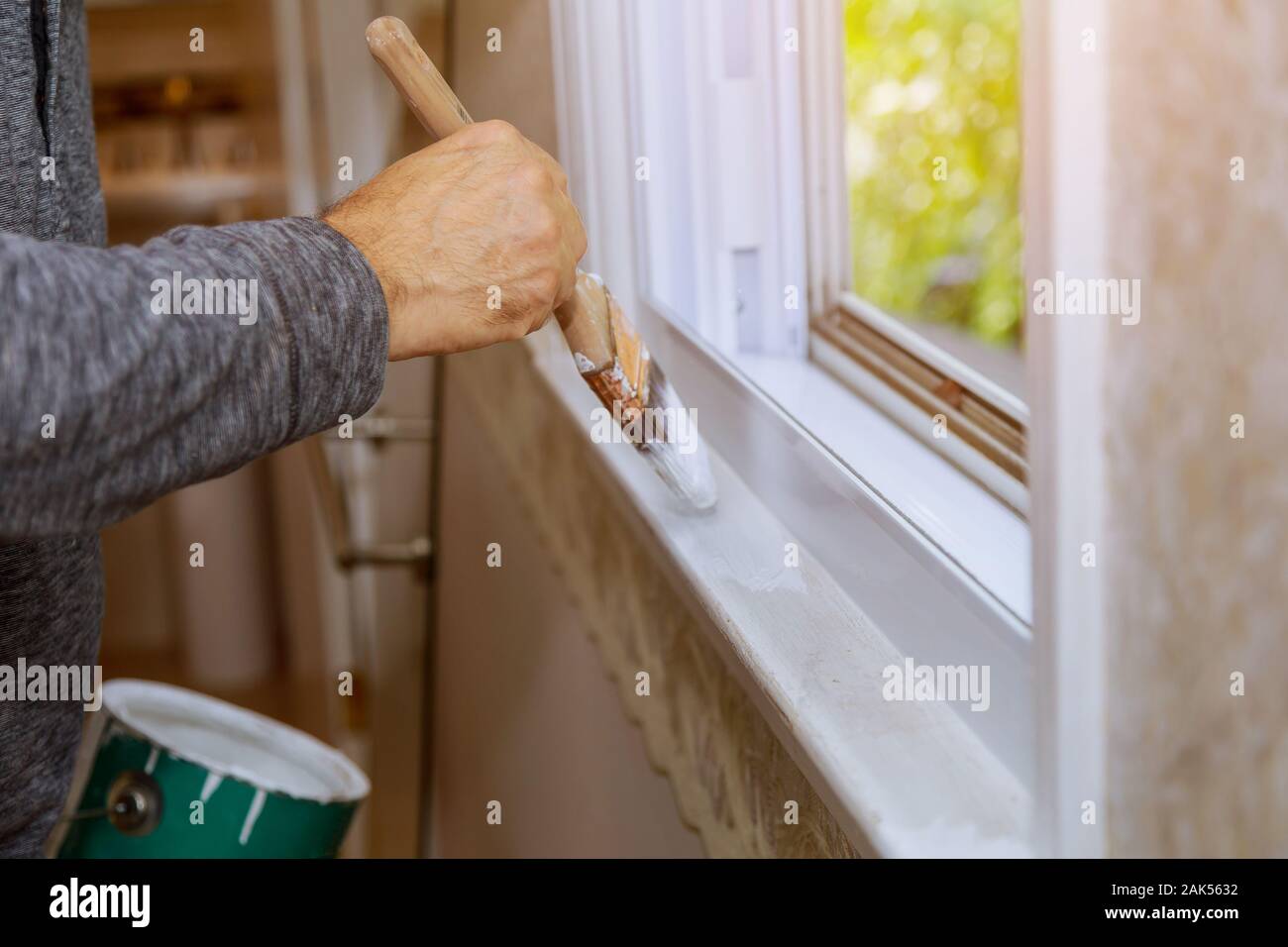 Worker painting window frame with white color at home Stock Photo Alamy