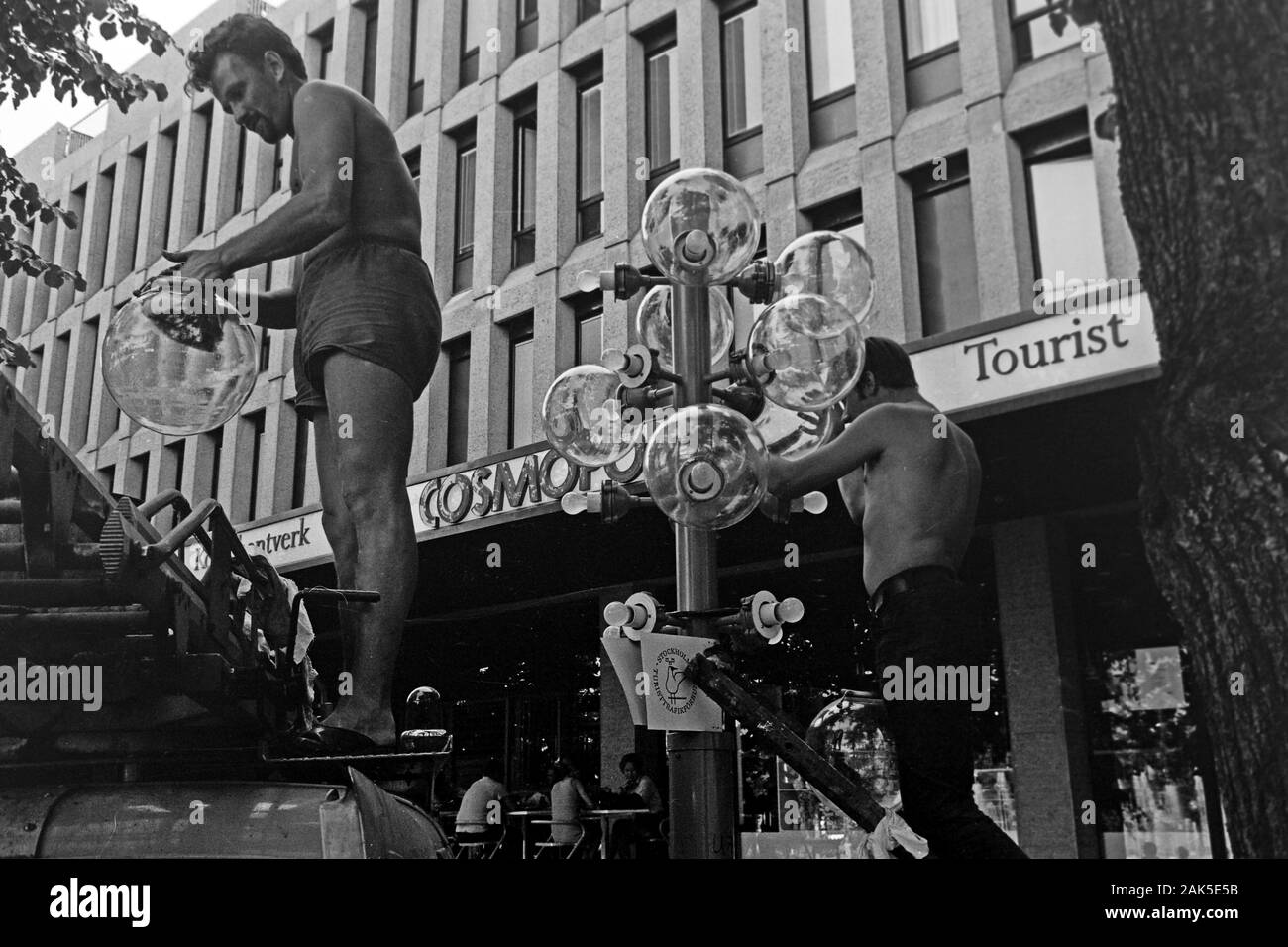 Lampenputzer bei der Arbeit vor dem Sverigehuset in der Hamngatan am Kungsträdgarden, 1969. Lamp cleaners at work in front of Sverigehuset on Hamngatan at Kungsträdgarden, 1969. Stock Photo