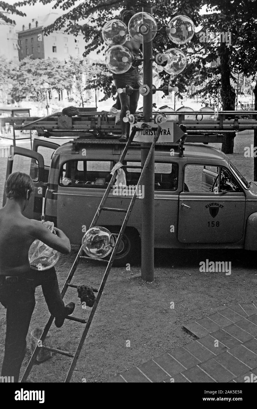 Lampenputzer bei der Arbeit vor dem Sverigehuset in der Hamngatan am Kungsträdgarden, 1969. Lamp cleaners at work in front of Sverigehuset on Hamngatan at Kungsträdgarden, 1969. Stock Photo