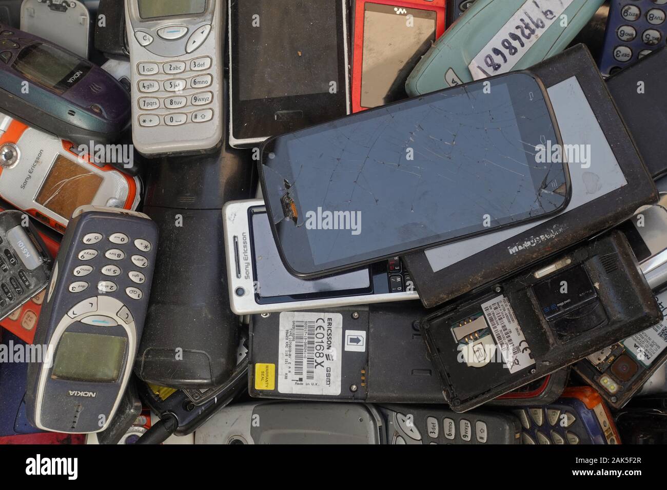 Athens, Greece - October 18, 2019: Pile of old cellphones broken smartphones and vintage mobile phones at junk shop. Stock Photo