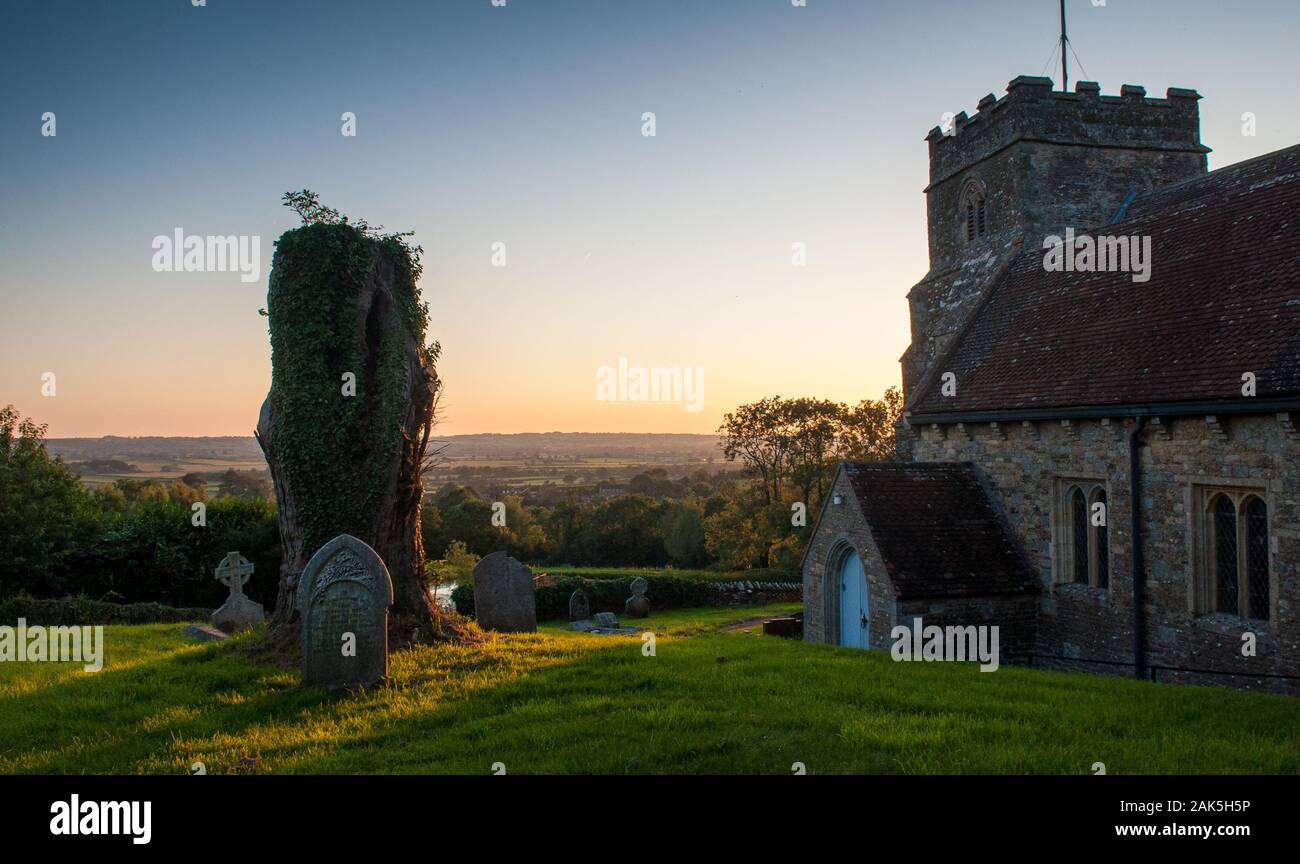 Gillingham, England, UK - July 22, 2012: The sun sets over All Saints Church and the agricultural landscape of the Blackmore Vale at Kington Magna in Stock Photo