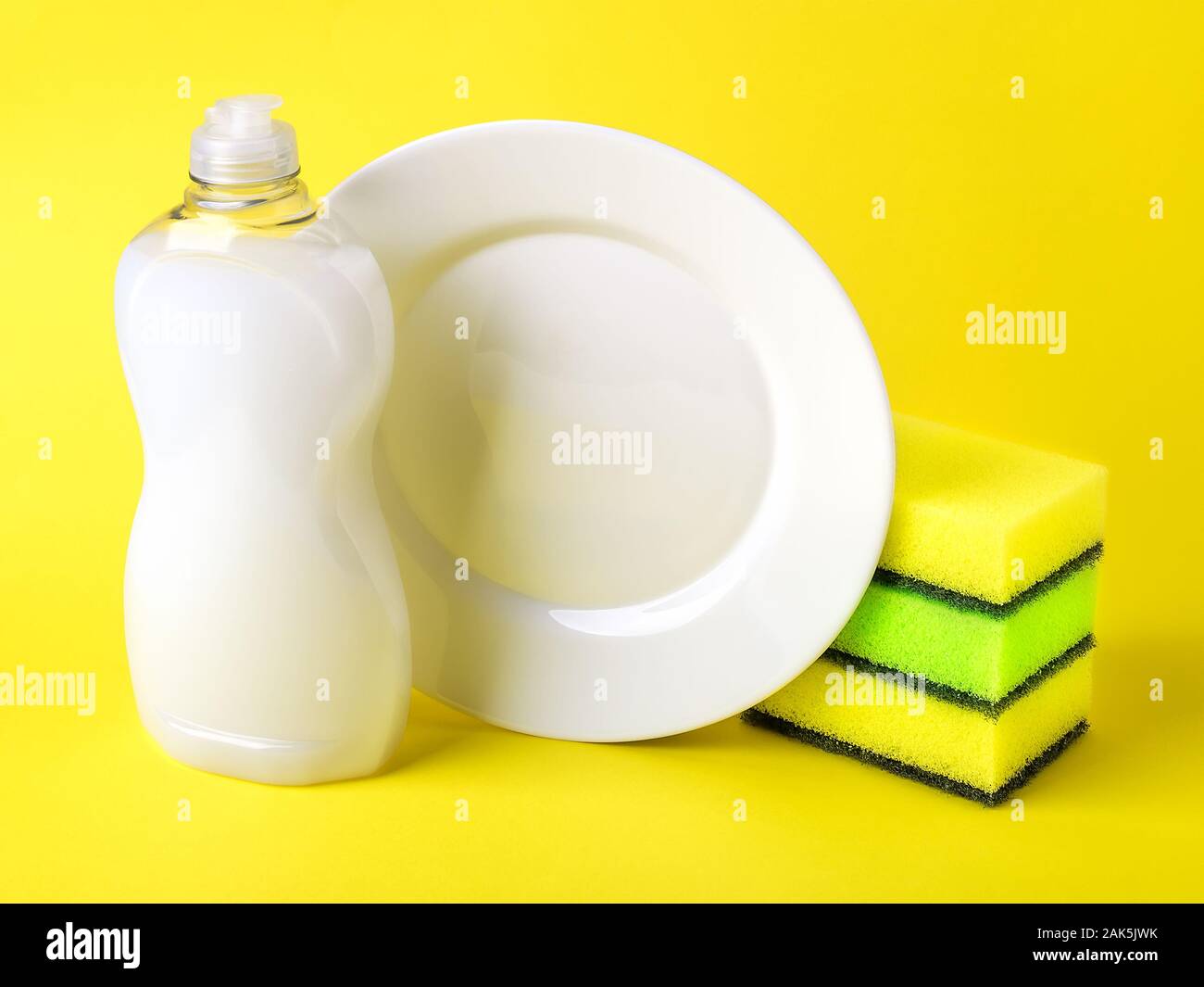 White dishwashing liquid in a plastic bottle, plate and three foam
