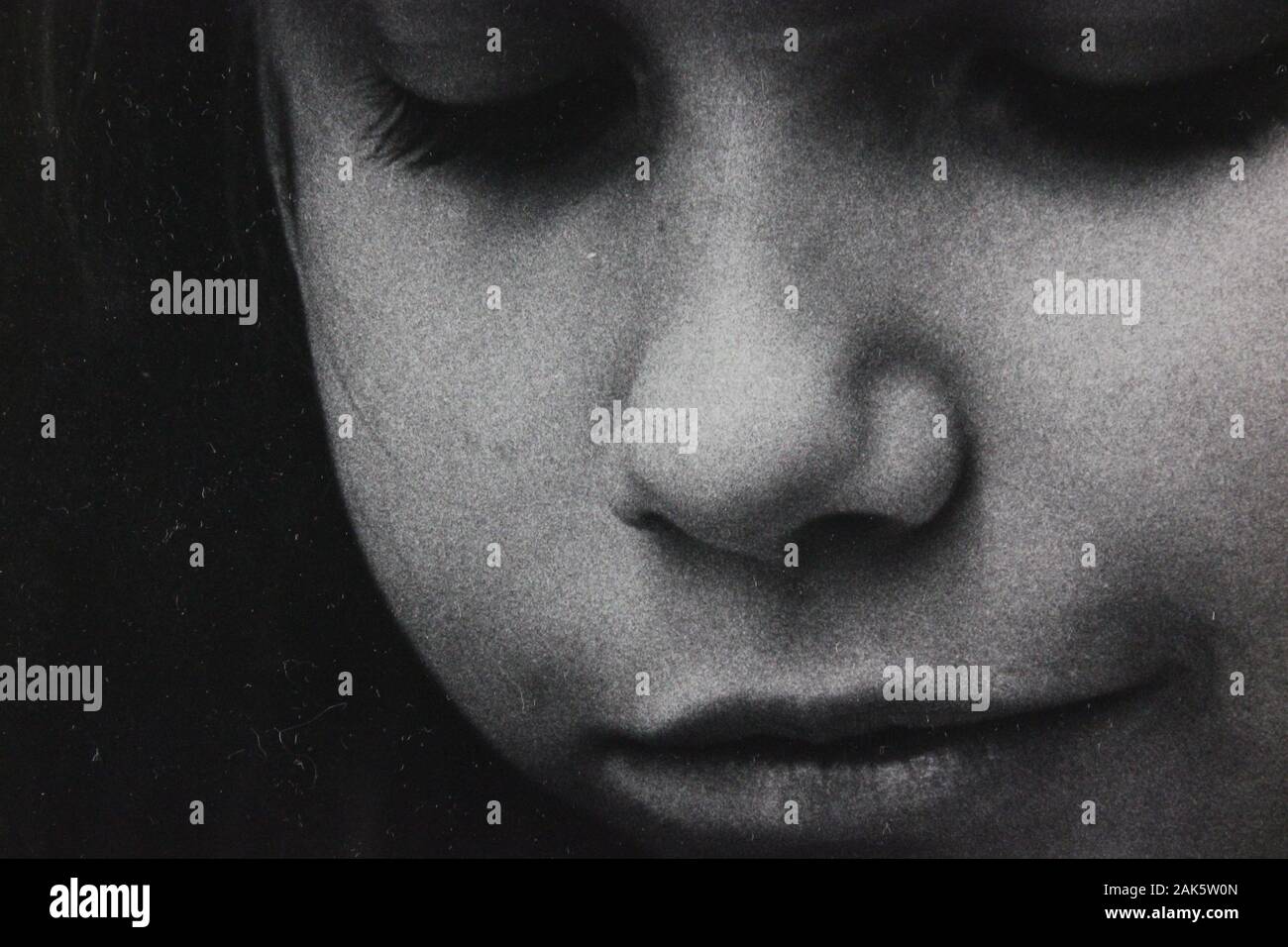 Fine 1970s black and white vintage photography closeup of a girl deep in thought Stock Photo