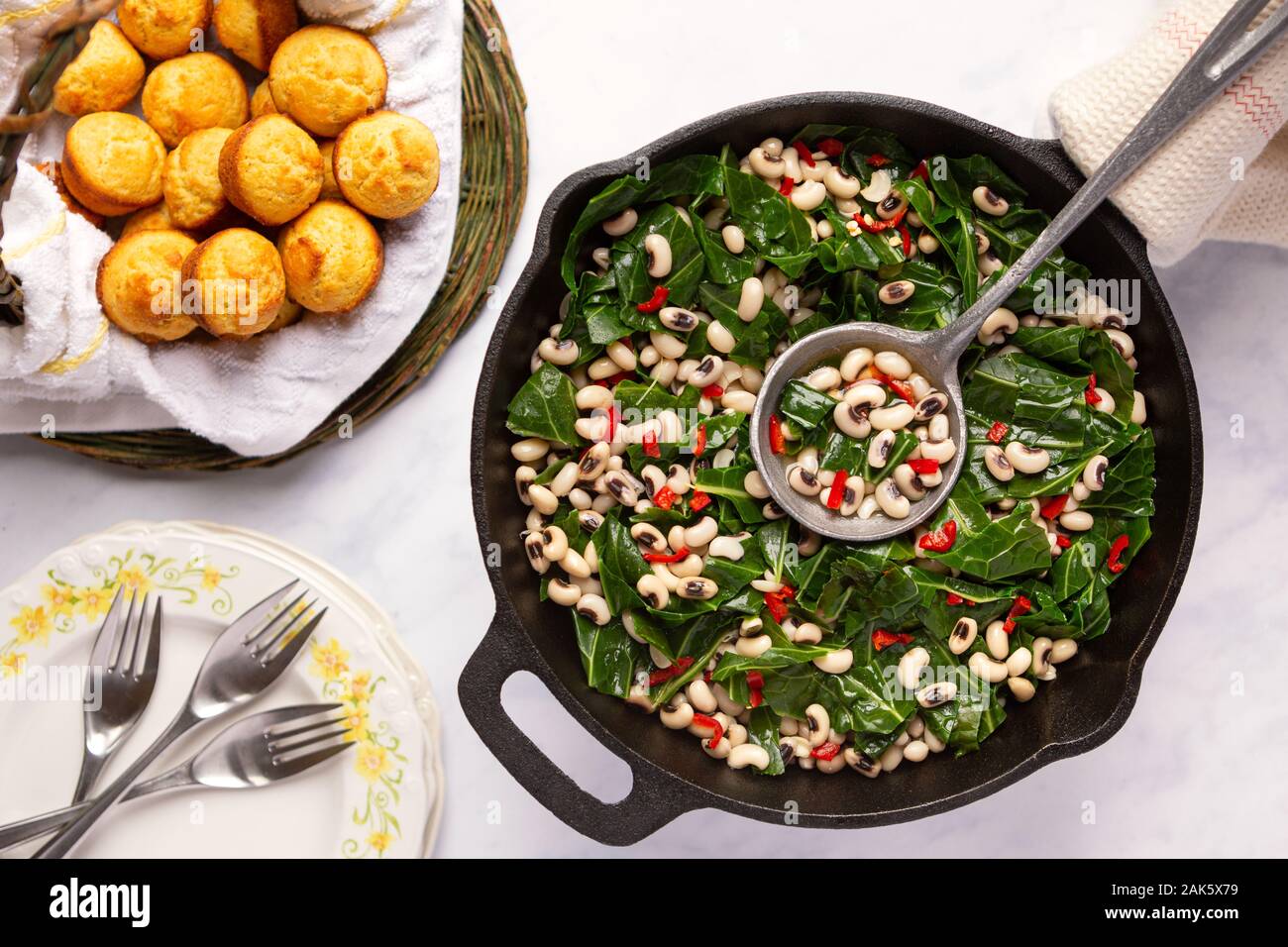 Overhead view of US southern dish of black-eye peas and collard greens with corn bread muffins Stock Photo