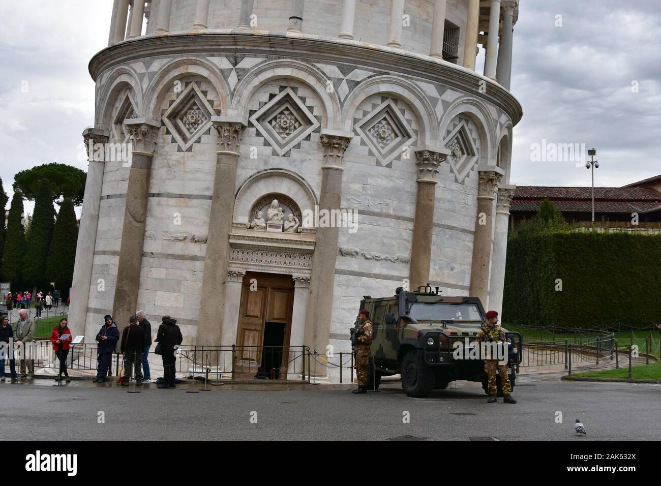 Pisa, Italy - April 11, 2018: The Square of Miracles in a dark rainy day. Two Italian soldiers / Guards in front of the leaning tower of Pisa Stock Photo