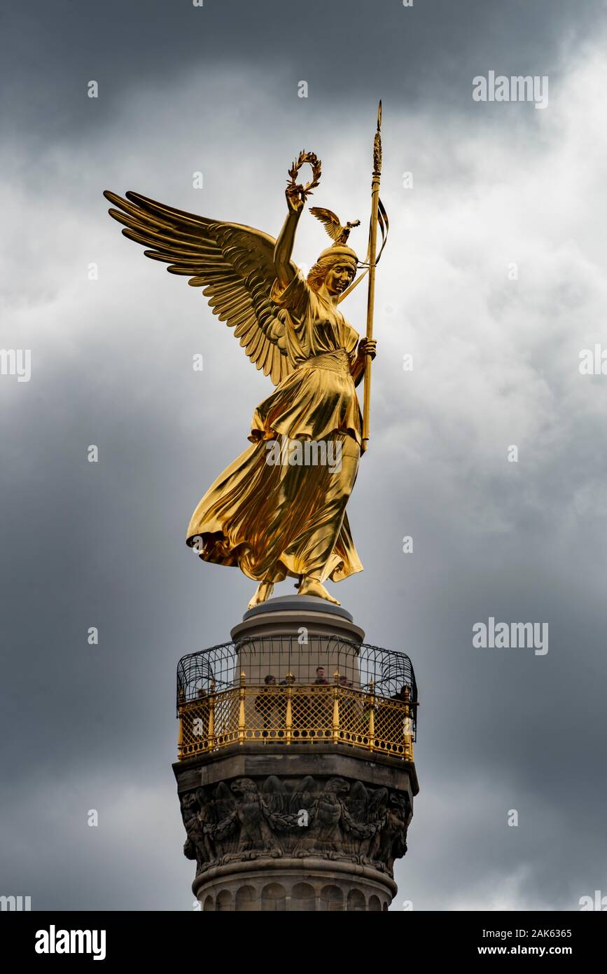 Golden bronze sculpture of Victoria on the Victory Column, inaugurated 1873, dark sky, Berlin, Germany Stock Photo