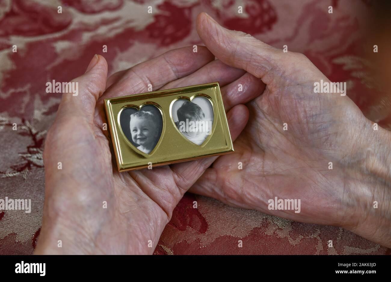 Symbol photo, mother love, hands of an old woman holding a picture frame with a portrait of a toddler, daughter, grandson, memory, Germany Stock Photo