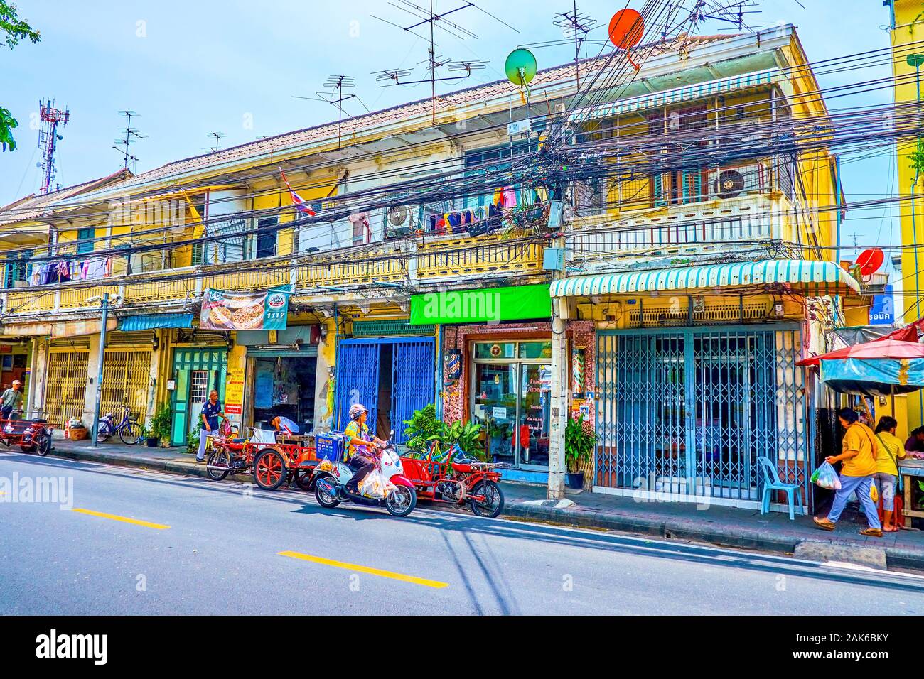 BANGKOK, THAILAND - APRIL 15, 2019: The small shabby residential building along Thanon Tanao street with cafes and shops, on April 15 in Bangkok Stock Photo