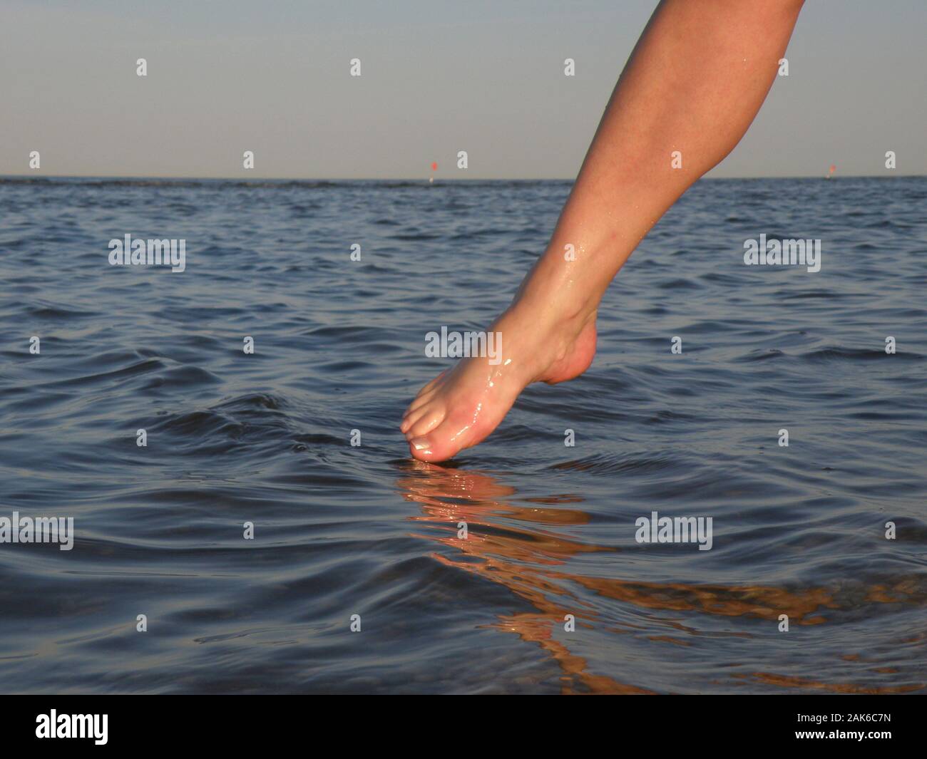 Woman who dipping the toe in the sea Stock Photo Alamy