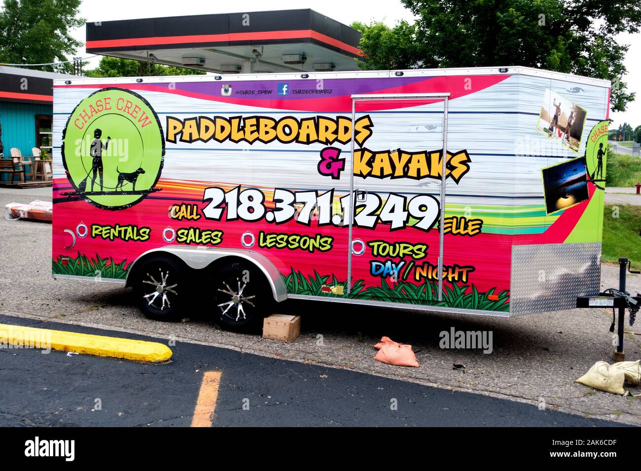 Artistically decorated travel trailer advertising paddleboard & kayak rental and sales. Battle Lake Minnesota MN USA Stock Photo