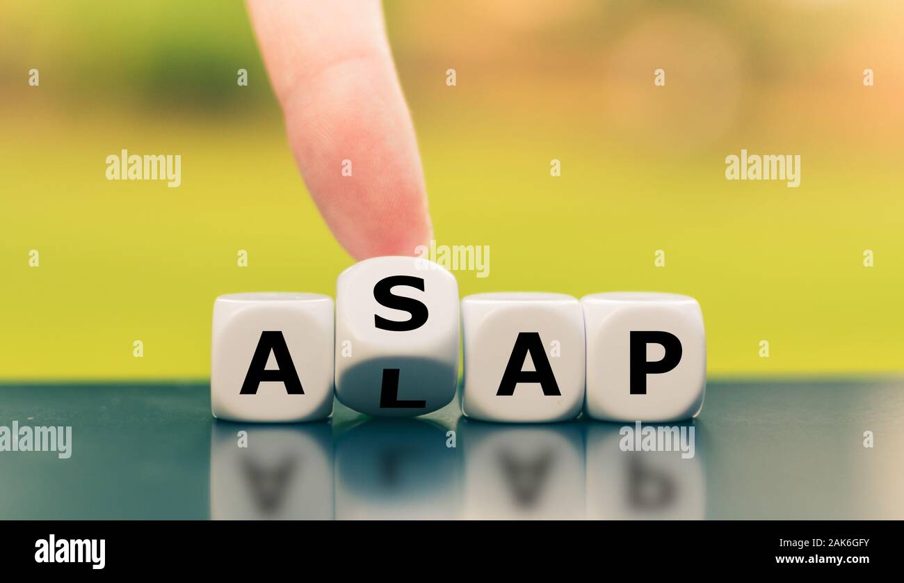 Hand turns a dice and changes the expression "ALAP" (as late as possible) to "ASAP" (as soon as possible), or vice versa. Stock Photo