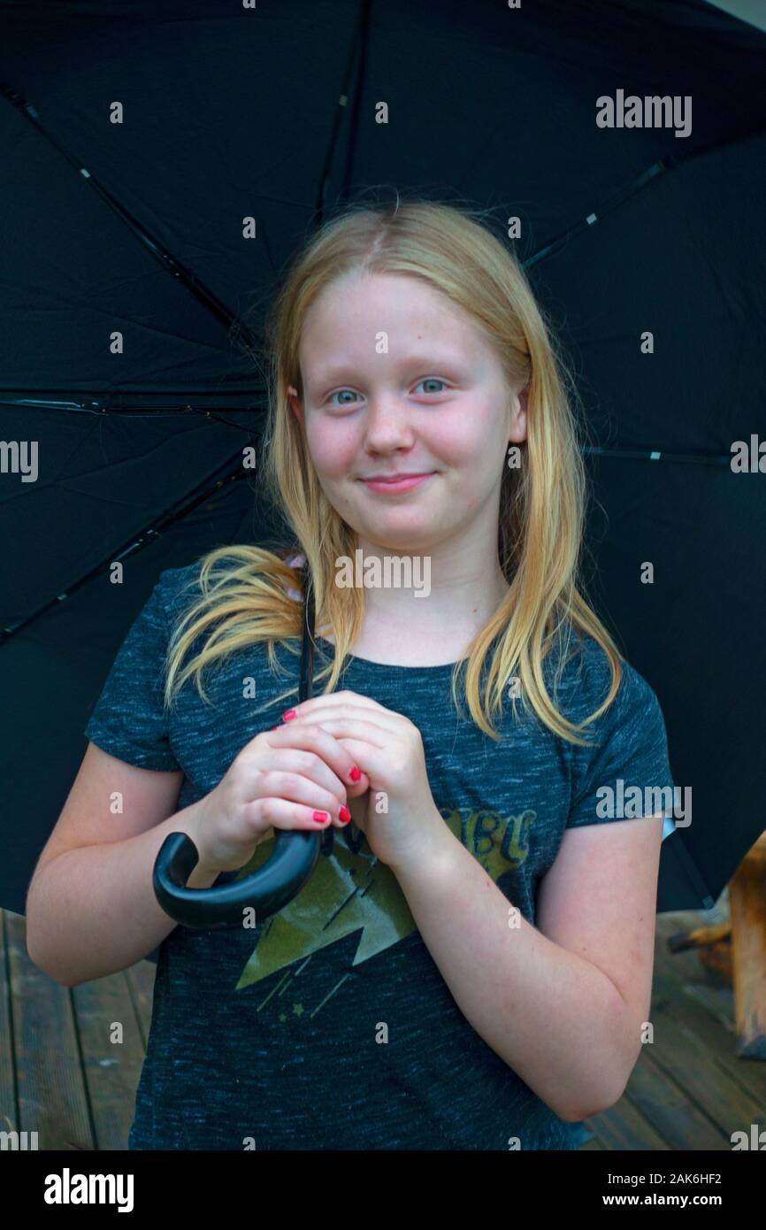 Charming young girl age 11 holding an umbrella. Zawady Gmina Rzeczyca Poland Stock Photo