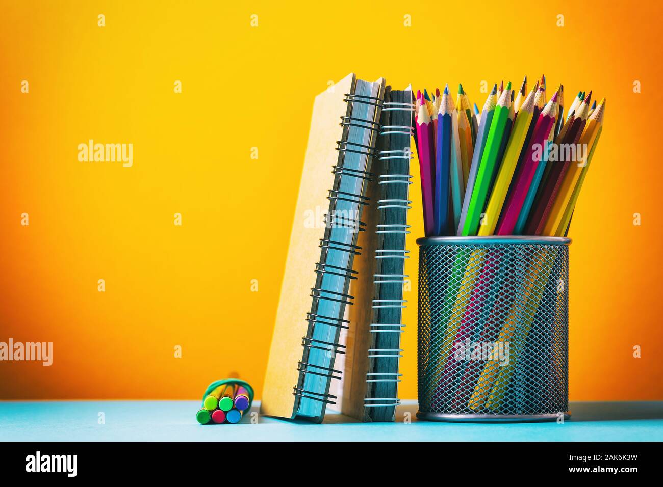 Various notebooks and pencils on a colored background with copy space Stock Photo