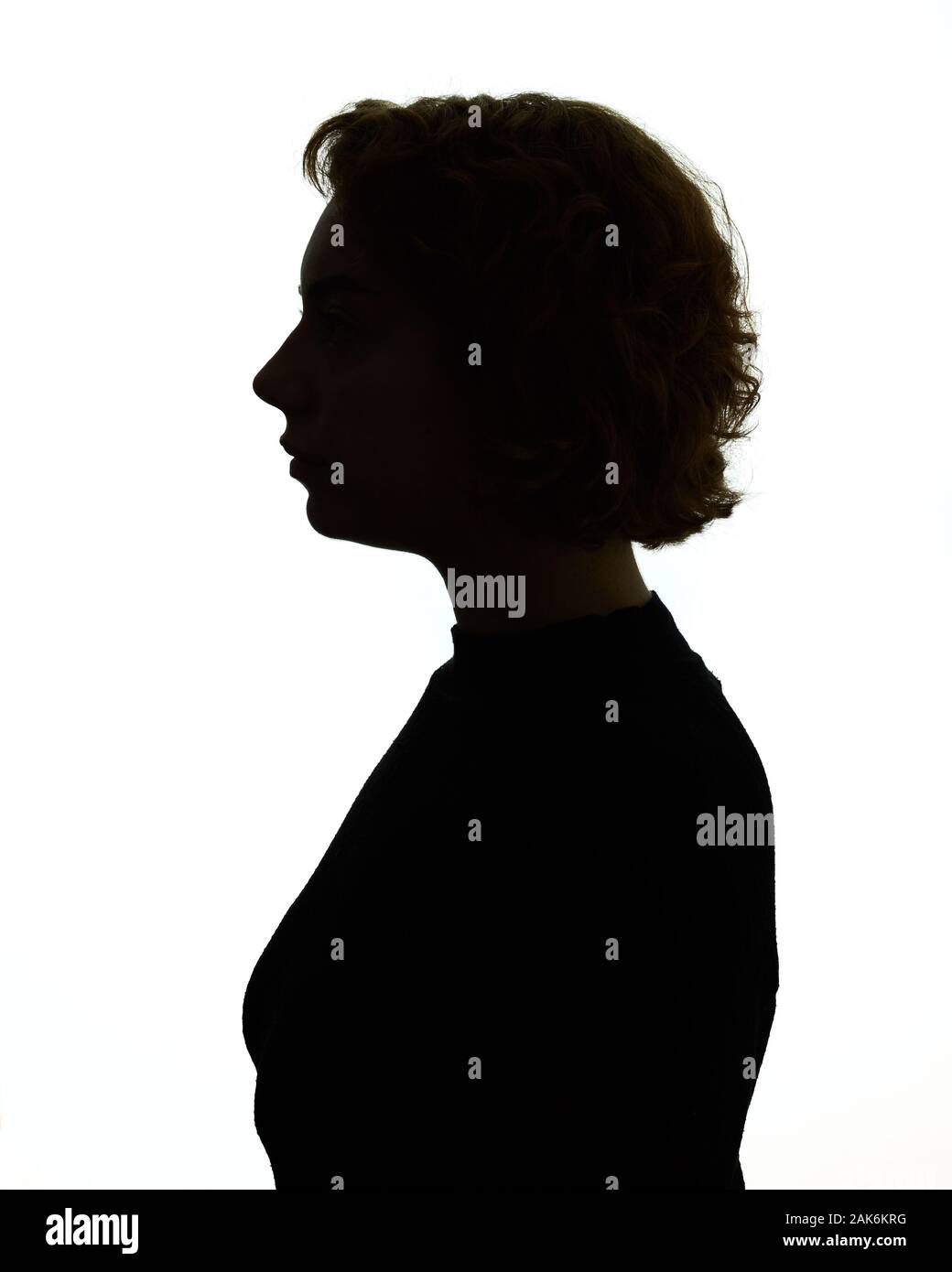 Silhouette of head and shoulders of a woman, backlit. Stock Photo