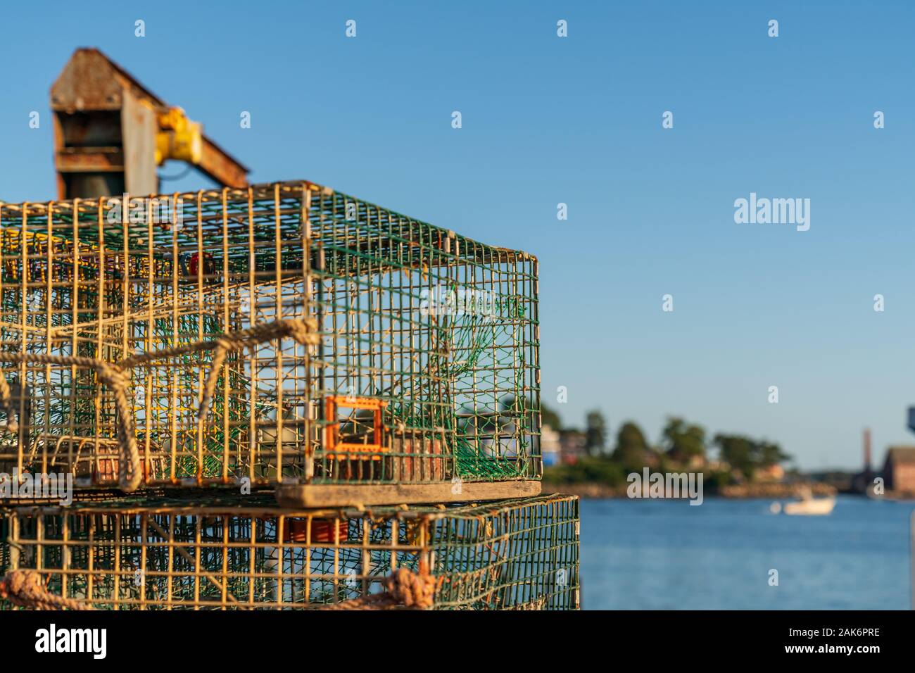 Old lobster traps look out onto Gloucester harbor and a blue sky in
